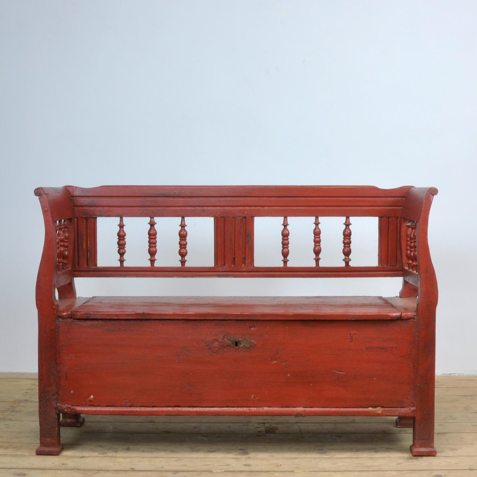 A charming box bench from Hungary, painted a striking shade of red. Under the seat a storage space.