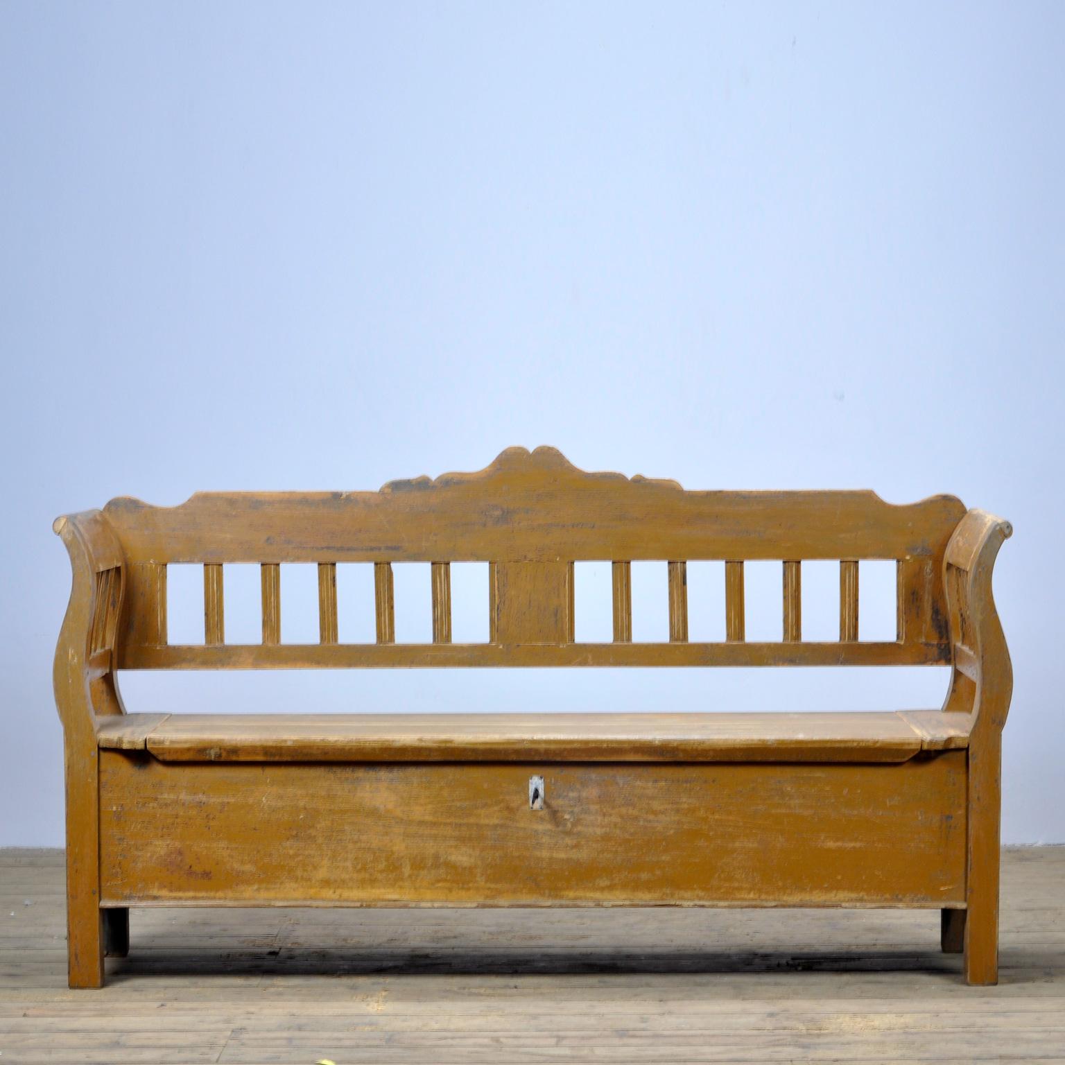 A charming bench from Hungary with the original paint. Over time and use, the paint has been worn away in places to the wood. With three storage spaces under the seat. With the original lock and key.