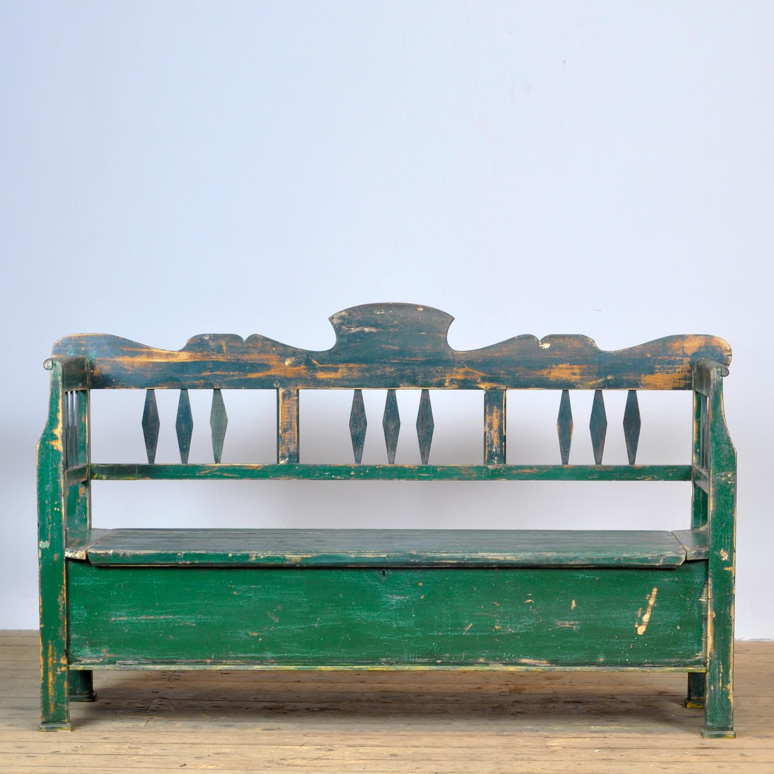 A charming bench from Hungary with the original paint. Over time and use, the green paint has been worn away in places to the wood. With storage space under the seat. The bench is stable.