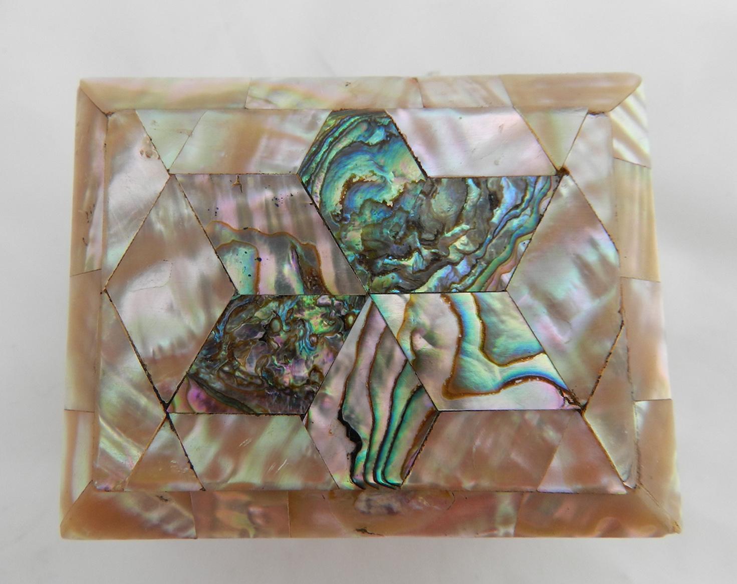 Rectangular box covered in Mother of Pearl and Abalone, circa 1900
Abalone forms a star shape on the lid
Push button to open
Stands on 4 small feet
Lined with light blue silk to the inside, the silk is lightly distressed through age and use not