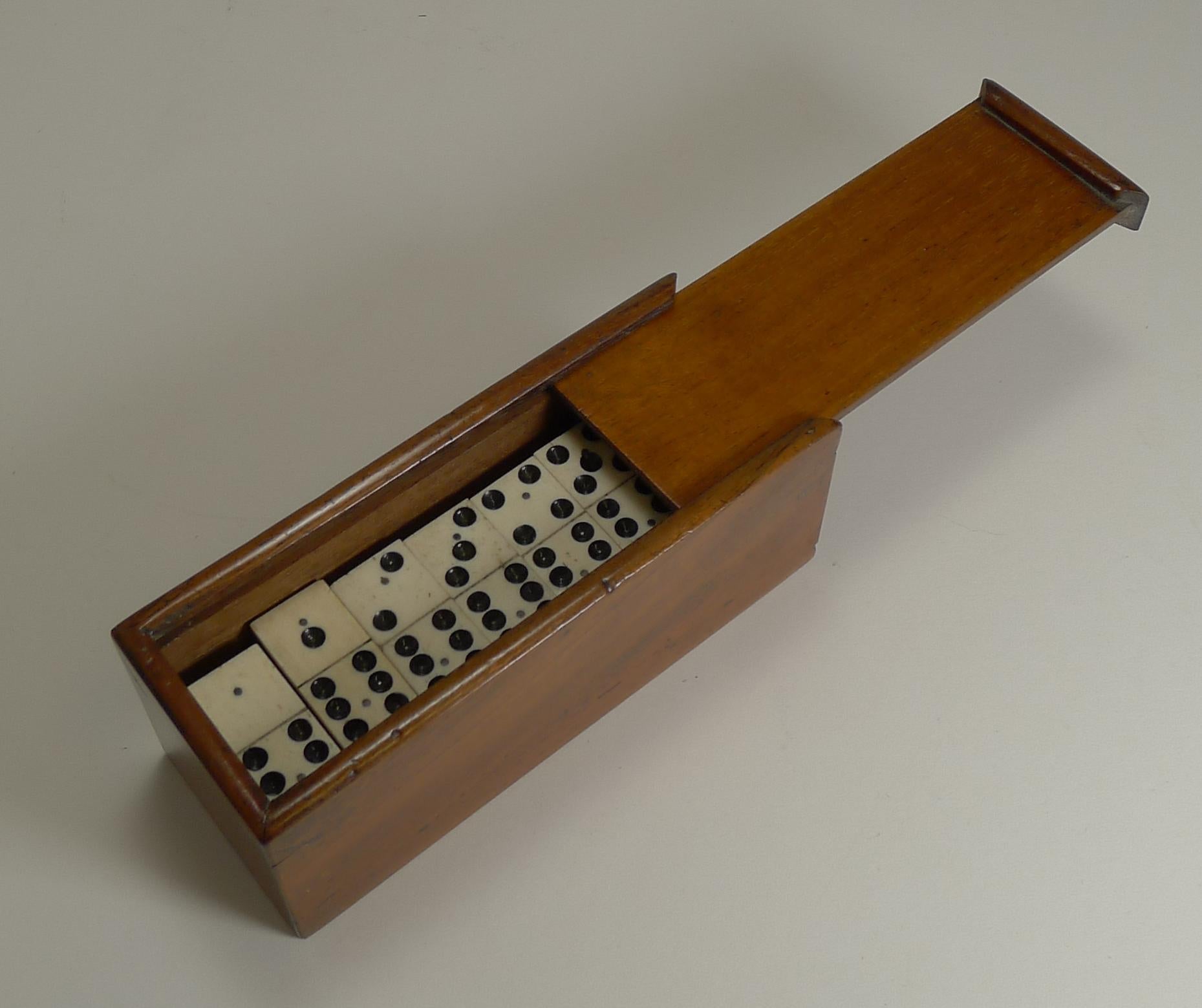 A charming set of late Edwardian dominoes, most unusual, these are a slightly smaller size; all in good condition with a handsome polished wooden storage box with a sliding lid.

The bone and ebony pinned together with small brass pins. The box
