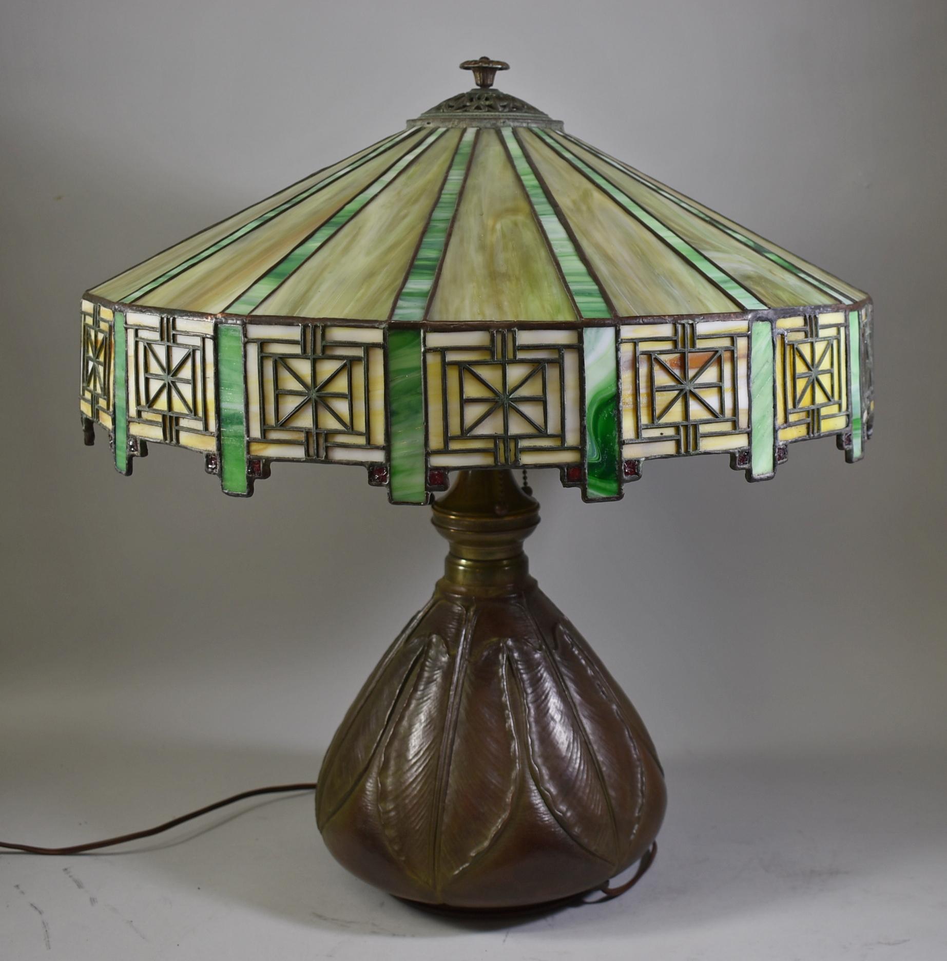 Antique Bradley & Hubbard Arts & Crafts leaded glass table lamp with Bryant sockets and original pulls. Adjustable height. Artichoke leaf pattern on the base. Great patina. Signed on base at socket cluster. 20