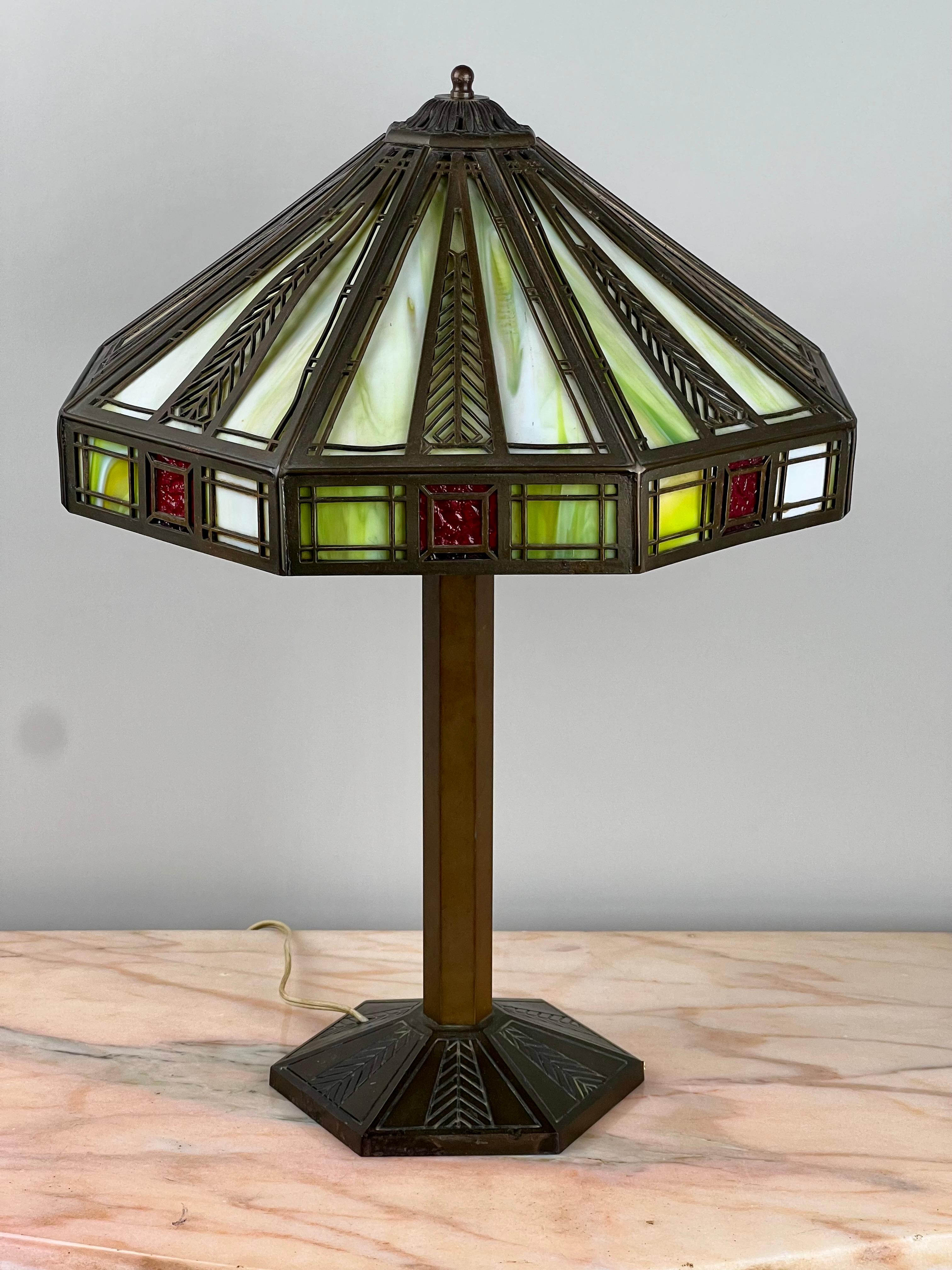 Cette étonnante lampe ancienne en verre de scorie de Bradley & Hubbard incarne l'élégance géométrique des mouvements Arts & Crafts et Prairie School. Son abat-jour octogonal présente des panneaux de verre de scories vertes et blanches panachées,