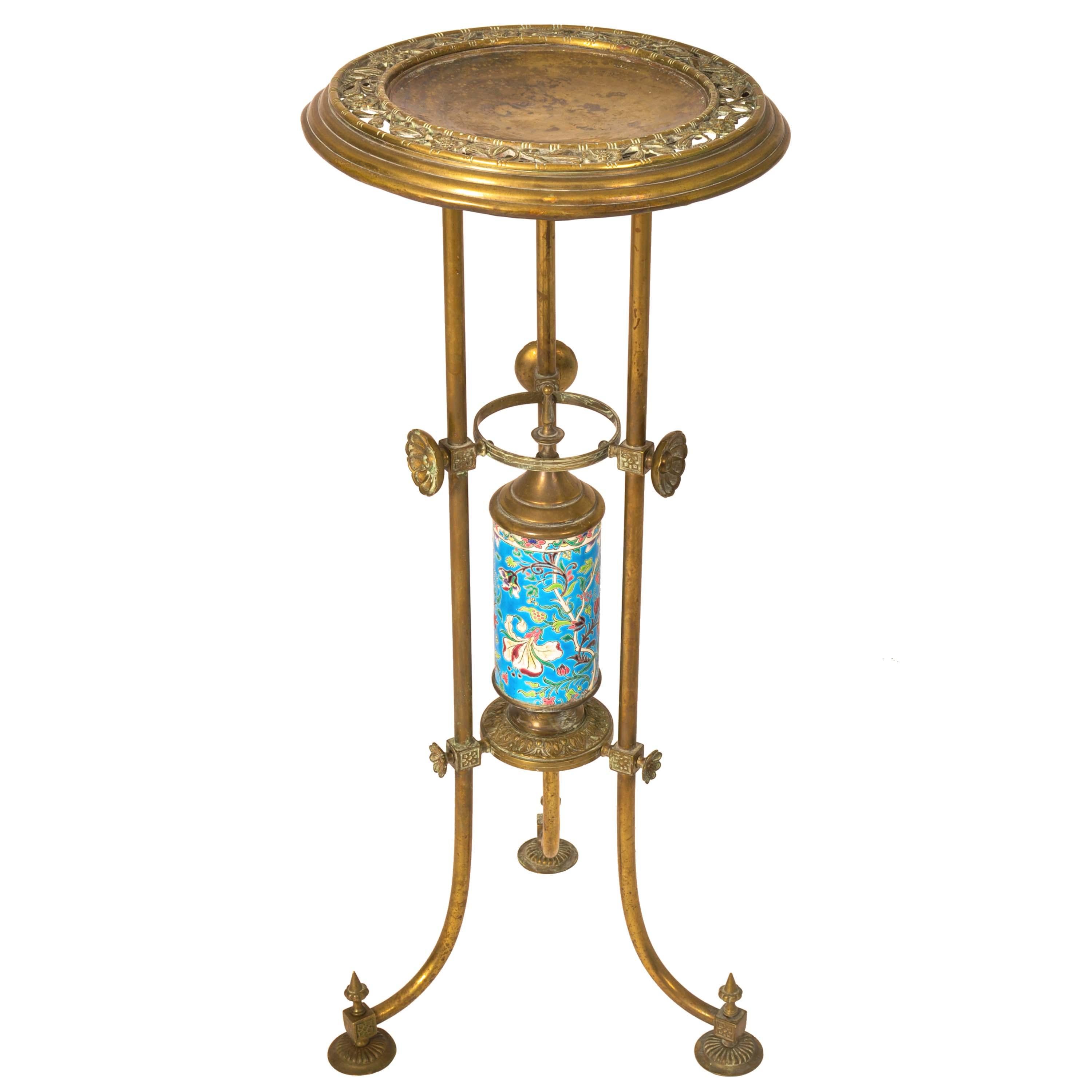 A rare & unusual American antique Aesthetic Movement brass plant stand, by Bradley and Hubbard and with a French Longwy faience pottery cylinder, circa 1875.
The tripod stand having a reticlated and engraved dished top with floral decoration, the