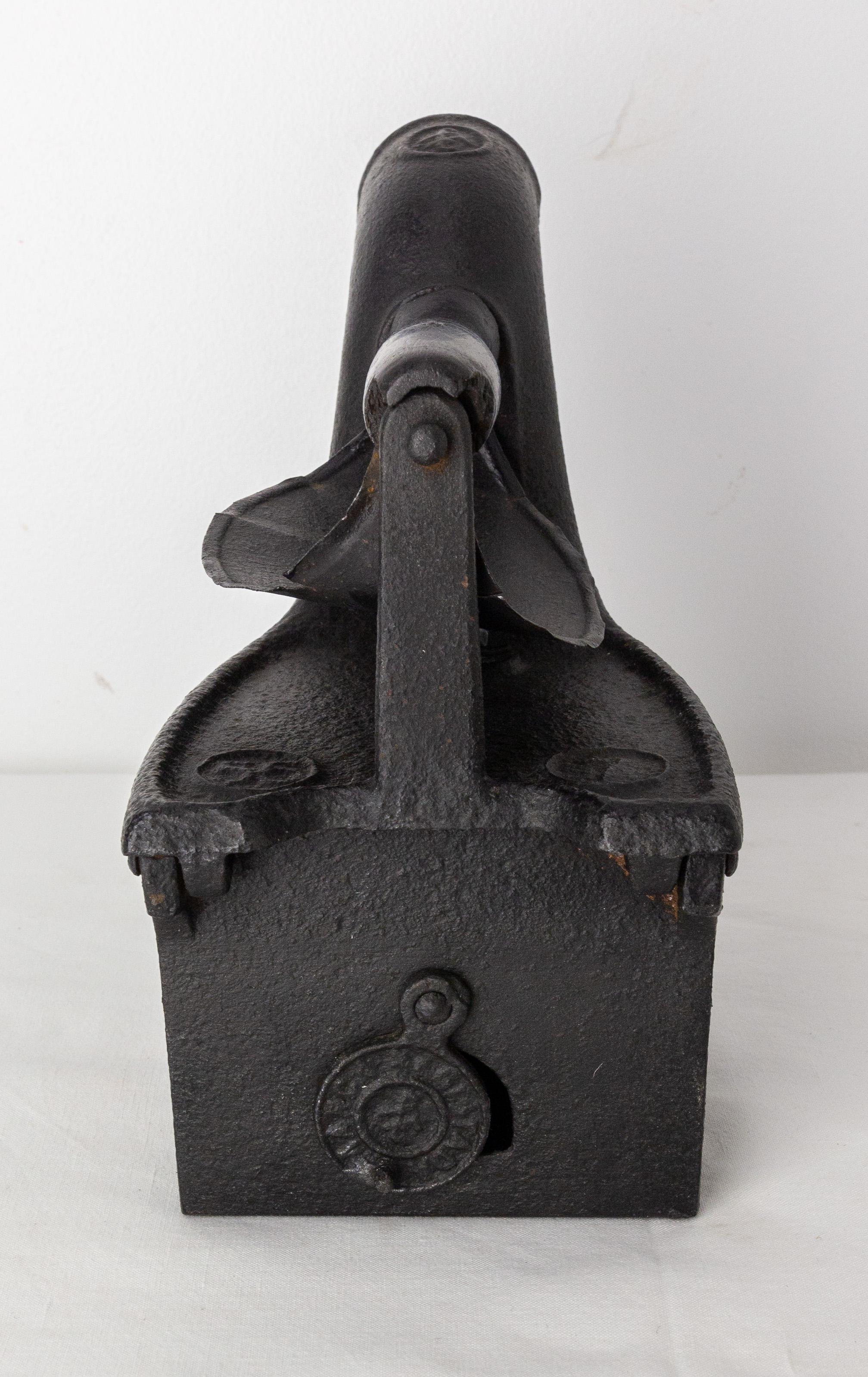 This cast iron trivet is particular Because it was created to put braises inside. 
This type of model represented a step forward for the laundress because it allowed to iron longer without having to rest the iron on the stove.
To allow the embers