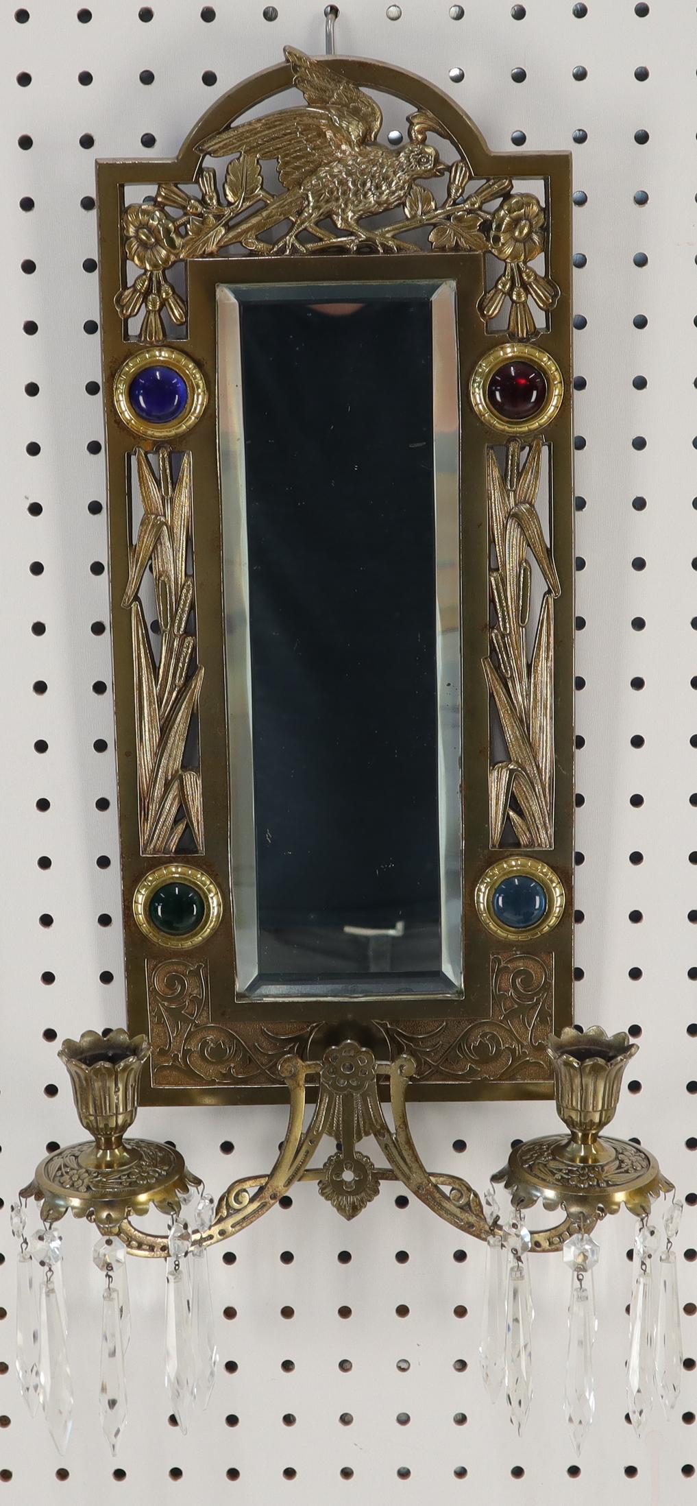 Antique brass sconce mirror with candle holders decorated with jewels.
