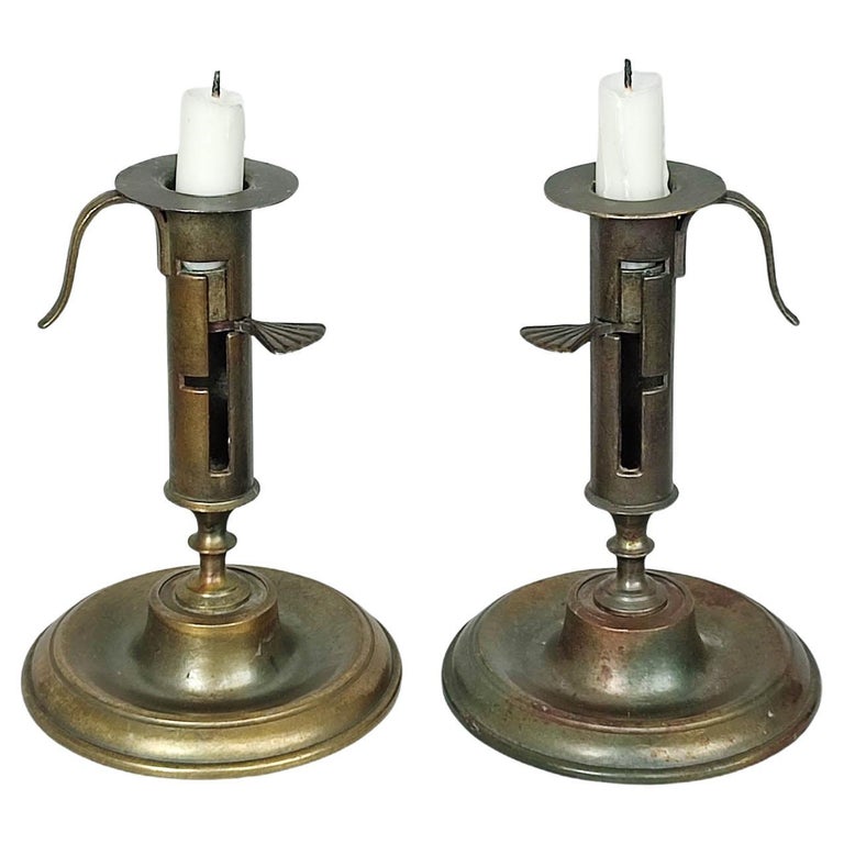 A Pair of Diamond and Beehive Push-Up Brass Candlesticks, 12