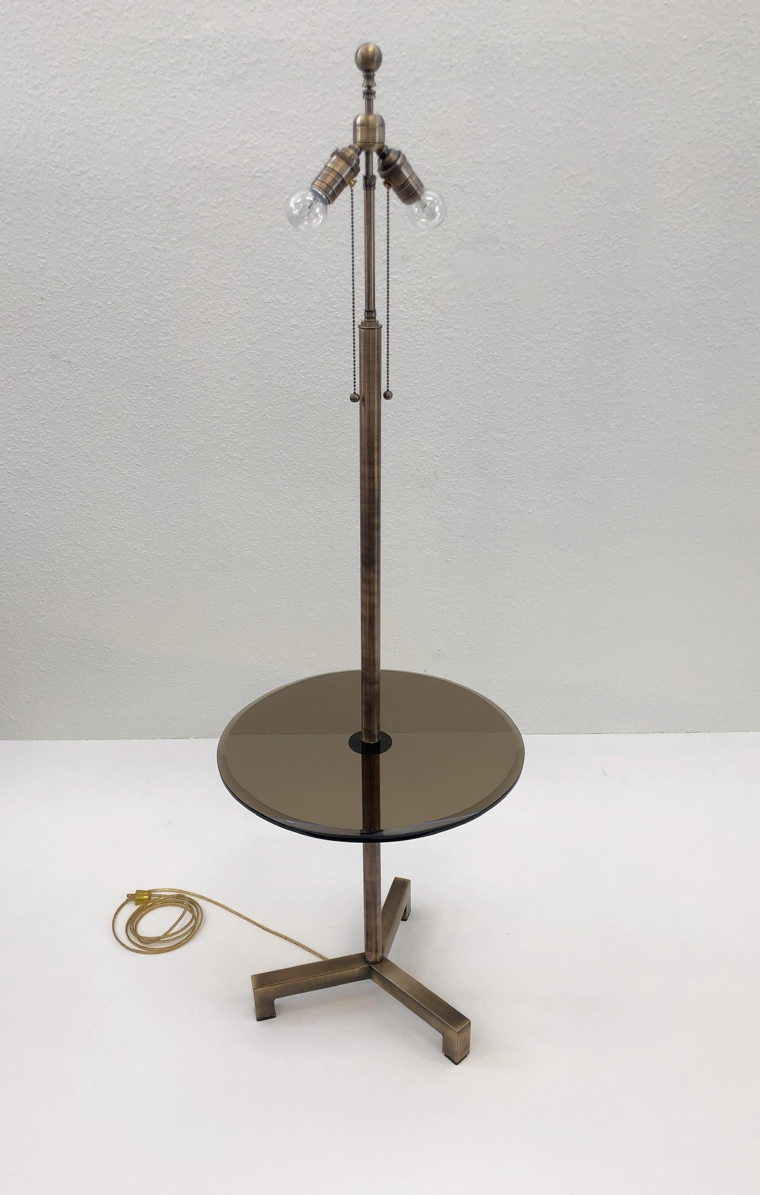 A beautiful antique brass floor lamp with a bronze beveled glass table design by Charles Hollis Jones. According to CHJ he designed this for Arthur Elrod in the 1960s. The lamp has been newly replated, rewired and new Lucite feet.
Dimensions:
The