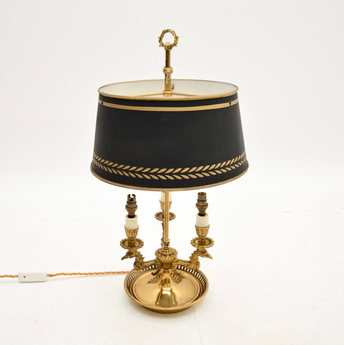 A beautiful antique brass and tole table lamp, made in England and dating from around the 1920’s.

It is of superb quality, with fine and intricate details, including eagles head candelabra. The tole shade is original and can be raised up and