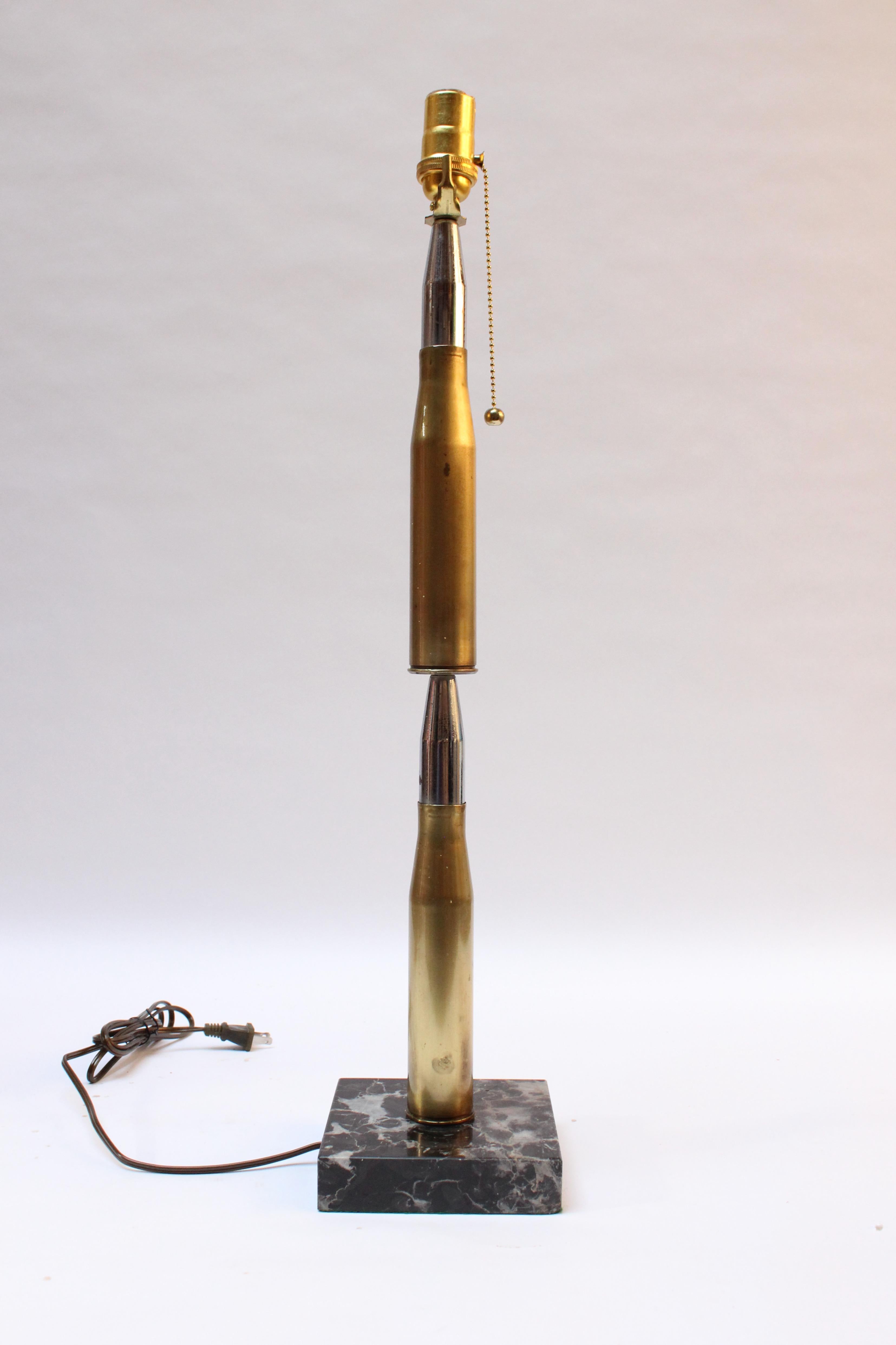 Trench Art lamp fashioned from two stacked brass and chrome high caliber artillery shells mounted to a black marble base (ca. 1918, USA).
Rich patina present, as shown, along with some chrome peeling.
Measures: Height of shell discounting socket: