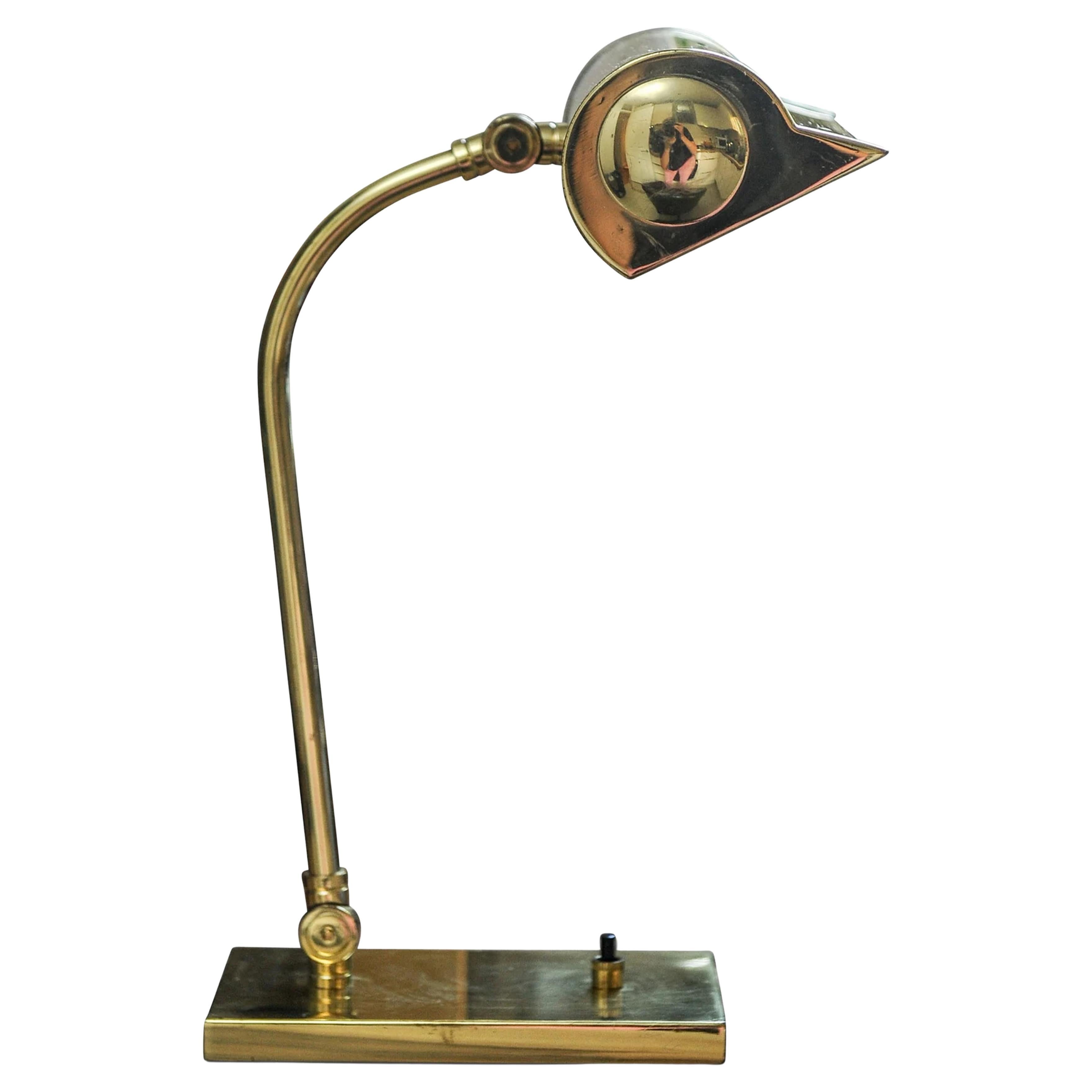 1940s Classic brass bankers lamp with brass pivotable shade with an ebonized desktop switch.

Full height: 36cm I Width of shade 23cm
Base: Depth 18.5 cm & width 10.5cm.