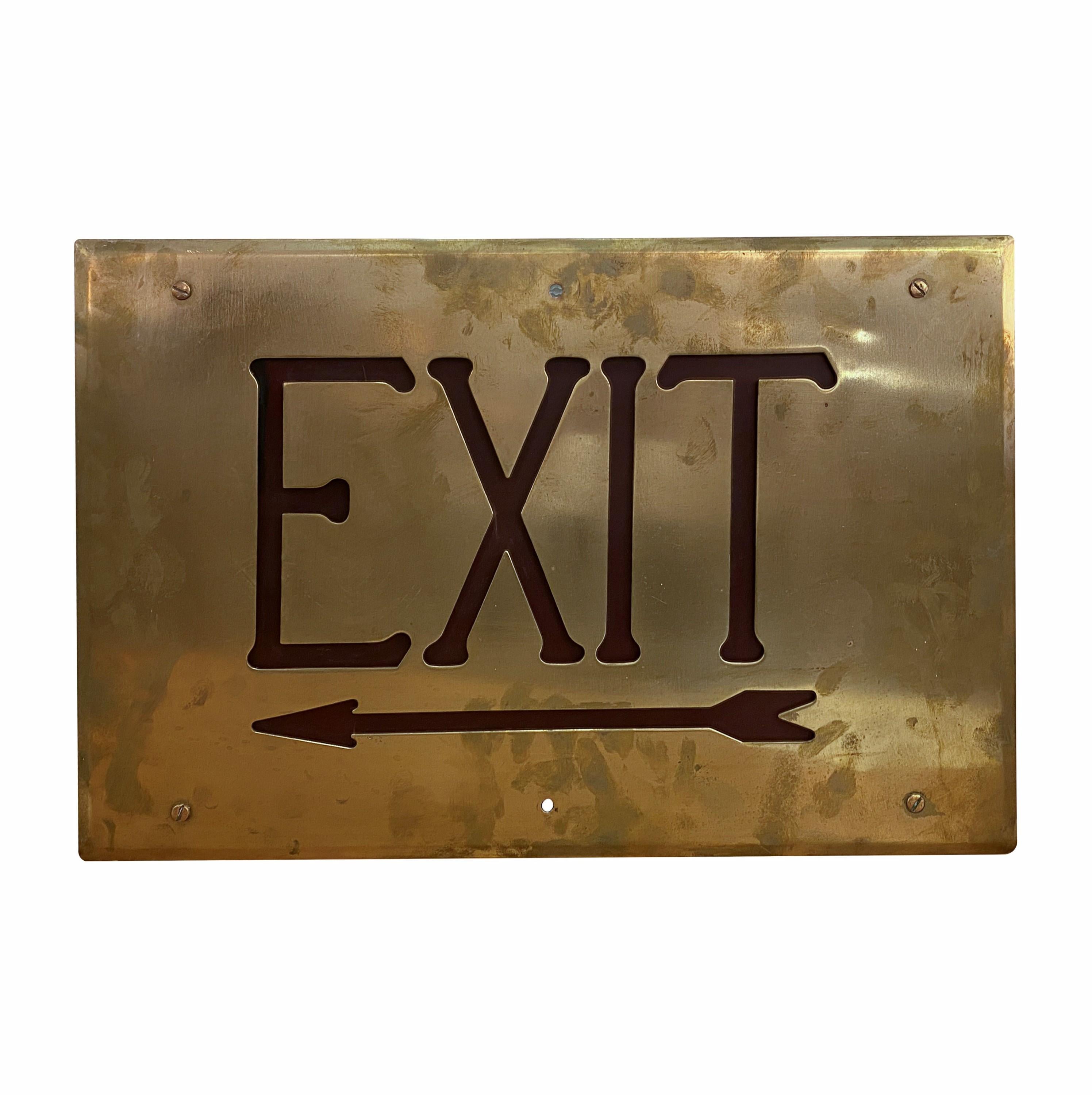 This antique brass beveled border exit faceplate sign features red glass letters, exuding timeless elegance. This piece serves as a sophisticated and eye catching directional accent in any space. It is in good condition without any major scratches