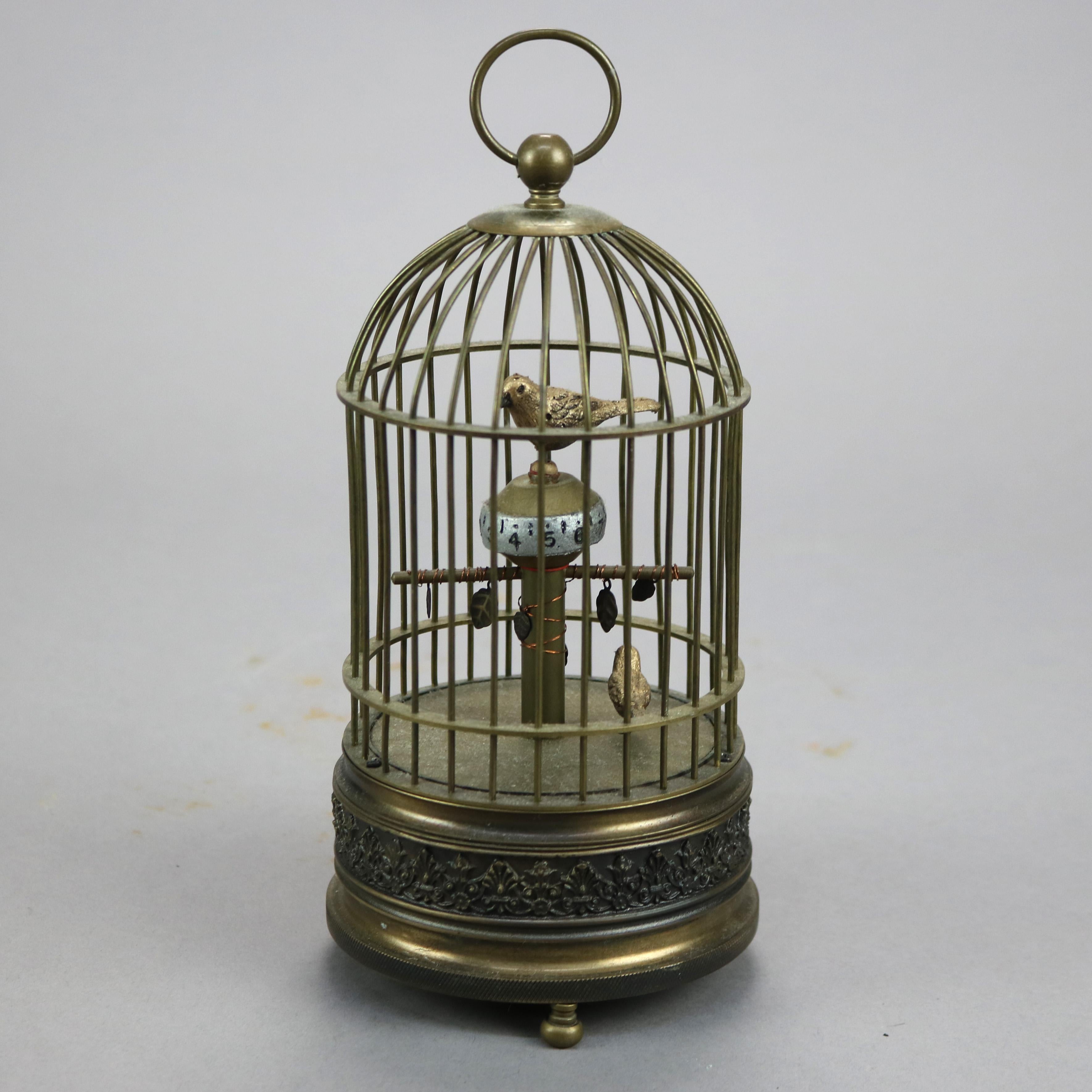 An antique figural desk clock offers brass construction with birds (finches) in cage having foliate embossed base, lower bird acts as the pendulum while upper bird spins with the time, wind-up, c1910

Measures- 8.5'' H x 4'' W x 4'' D.