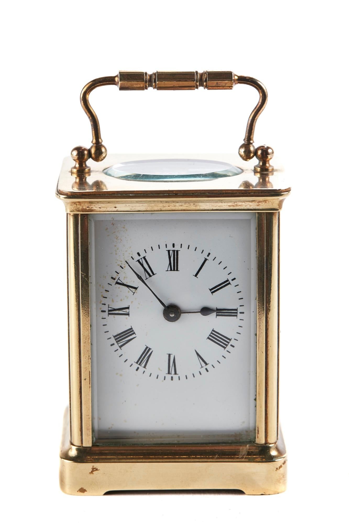 This is an antique brass carriage clock with shaped handle, bevelled glass, enameled dial, 8 day French movement. It is in perfect working order.