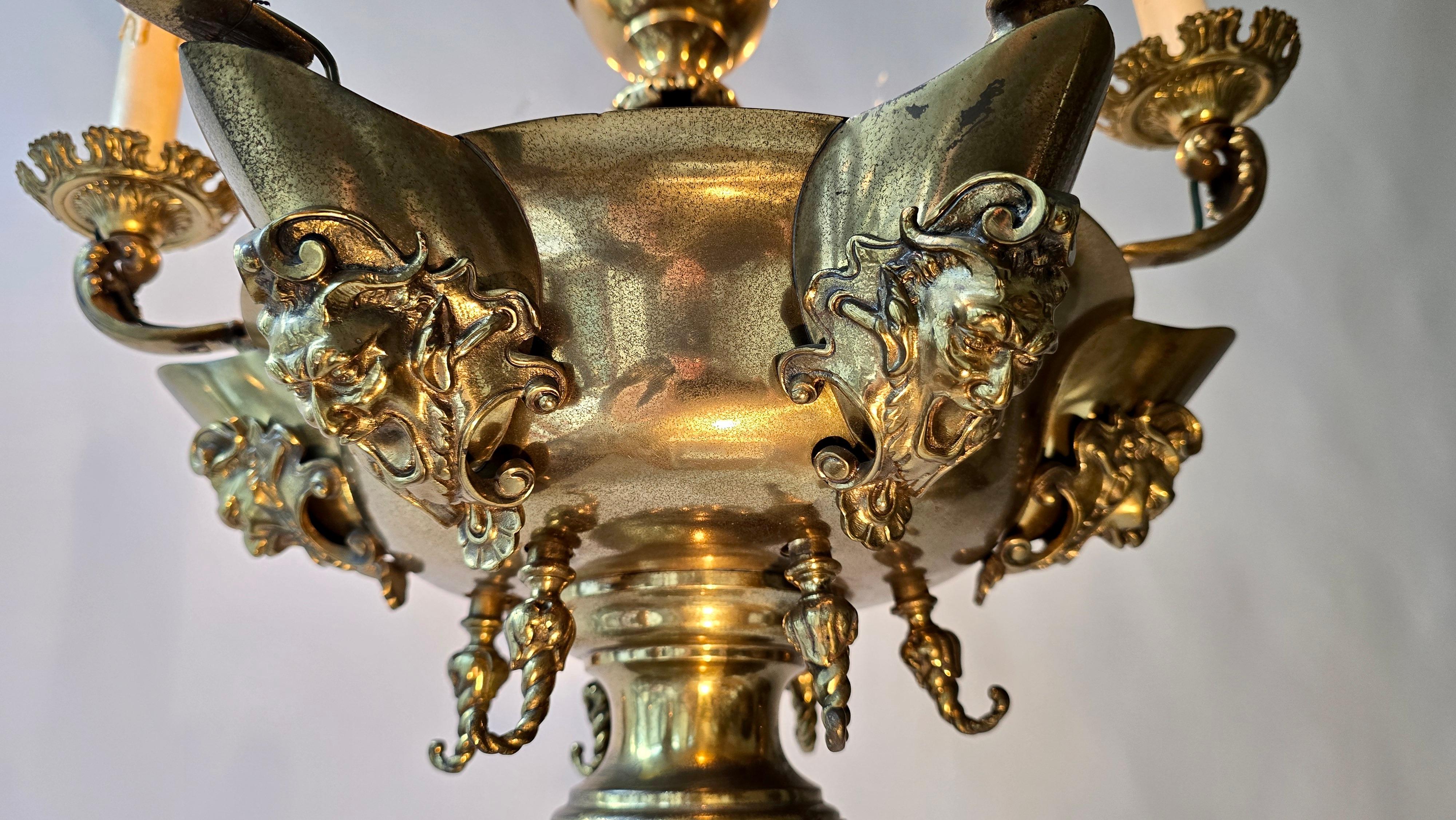 Laiton Antique  Lustre en laiton avec masques grotesque en vente