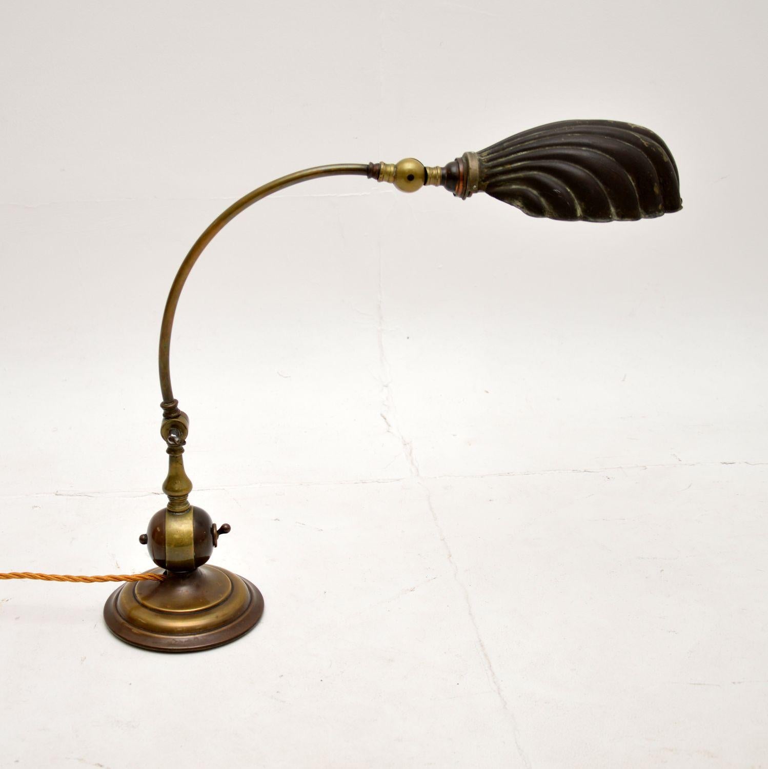 A beautiful antique brass clam shell bankers desk lamp. This was made in England, it dates from around the 1920-30’s.

It is of superb quality with a lovely design. The angle can be adjusted with joints at the neck and base, the shade can also