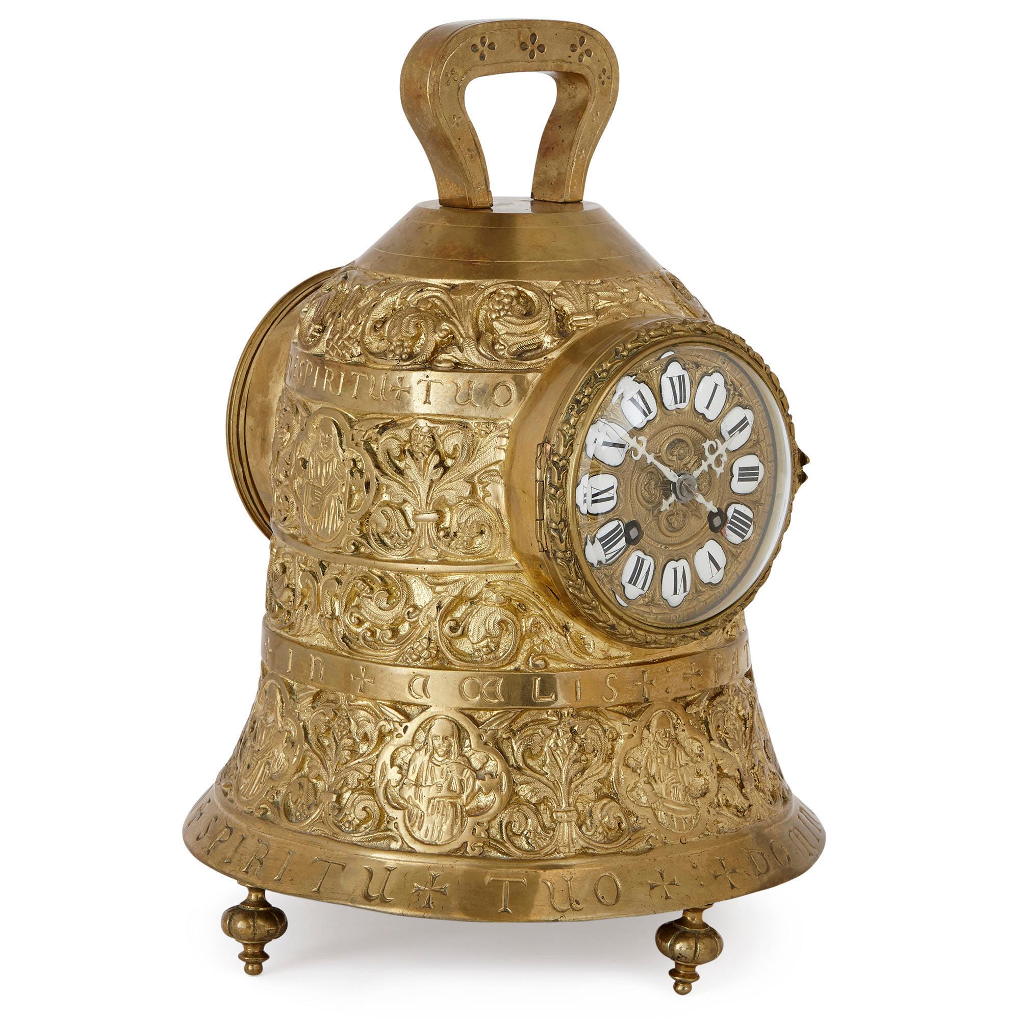 This three-piece brass clock set is wonderfully designed to look like a collection of Christian church bells. The mantel clock features a bell-shaped body which is set on four turnip feet. The clock’s body is decorated with stylised scrolling vines