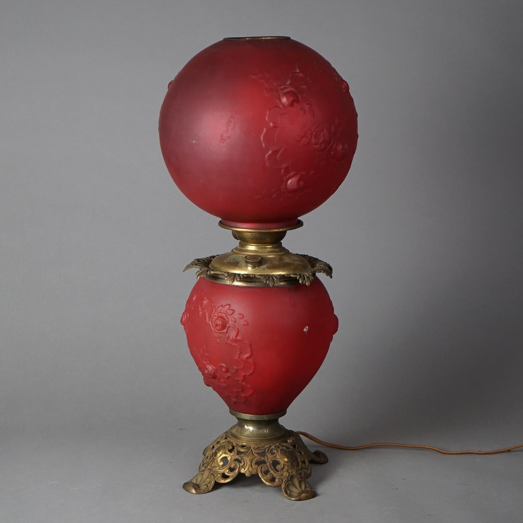 An antique Gone-With-The-Wind (GWW) table lamp offers cranberry glass font and globe with cast brass frame; electrified; c1890

Measures - 23.5