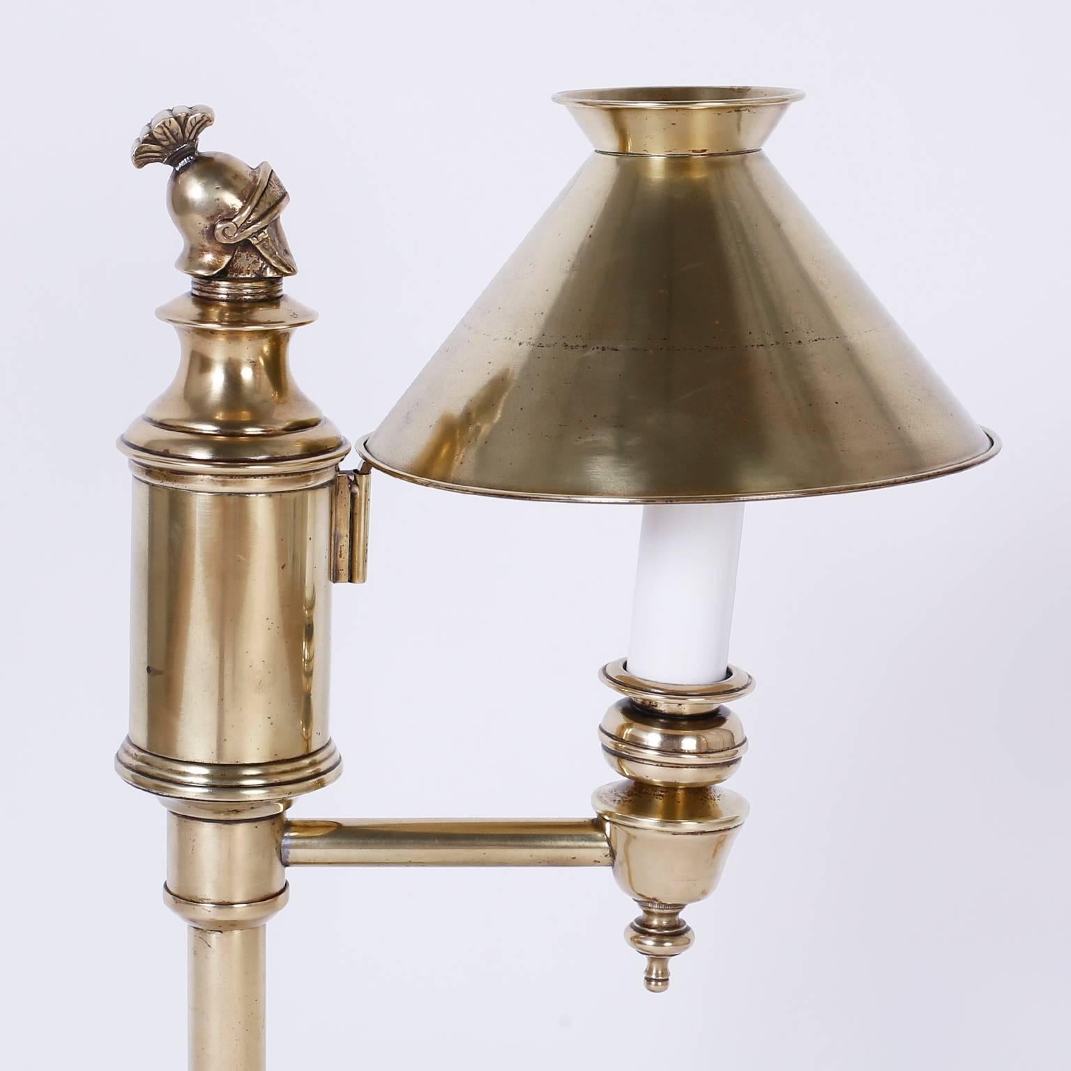 Handsome brass desk or students lamp featuring a knights helmut a top
the center post, brass shade and a Classic timeless form. Hand polished
and lacquered for easy care.