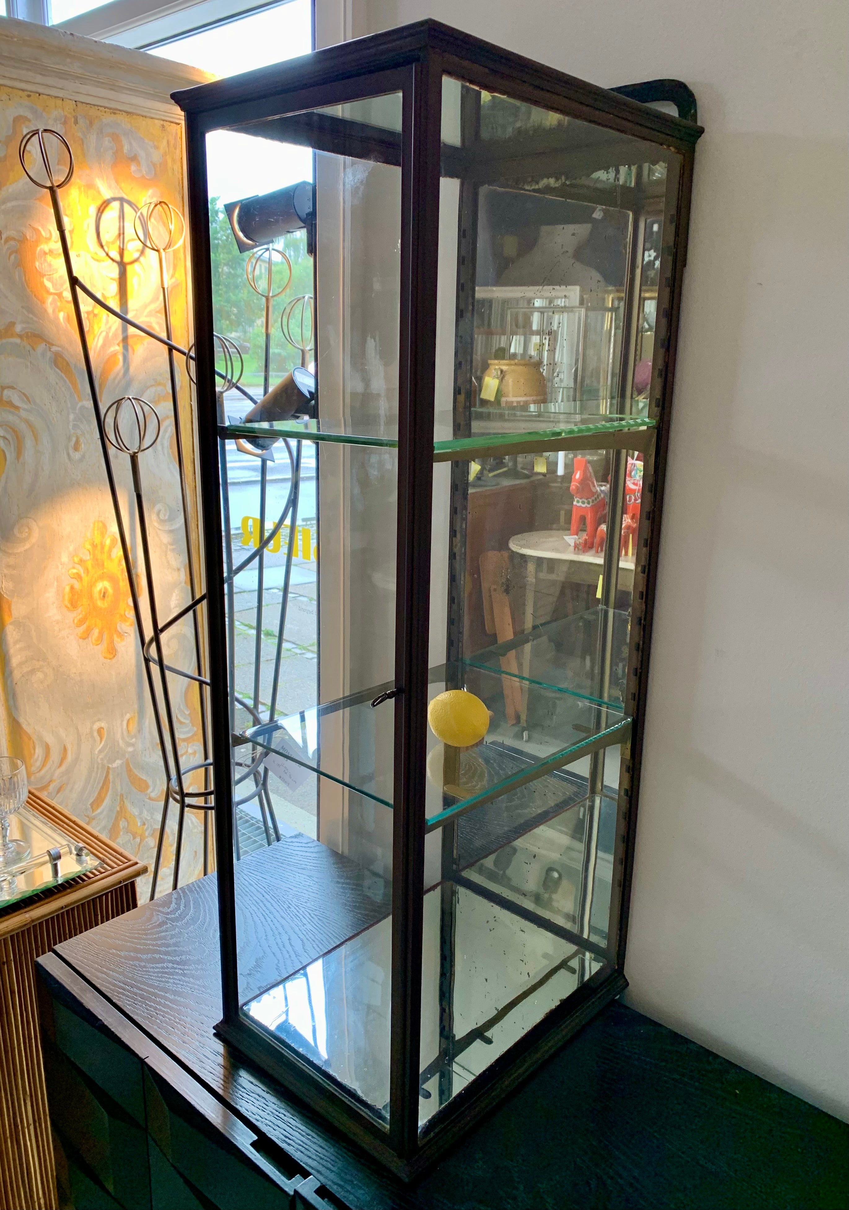 Gran vitrina francesa de latón antiguo con 2 estantes de cristal, parte superior e inferior espejadas, así como parte trasera. La vitrina ha sido fabricada por el prestigioso fabricante parisino S.I.V. (Société Industrielles de Vitrines) y puede