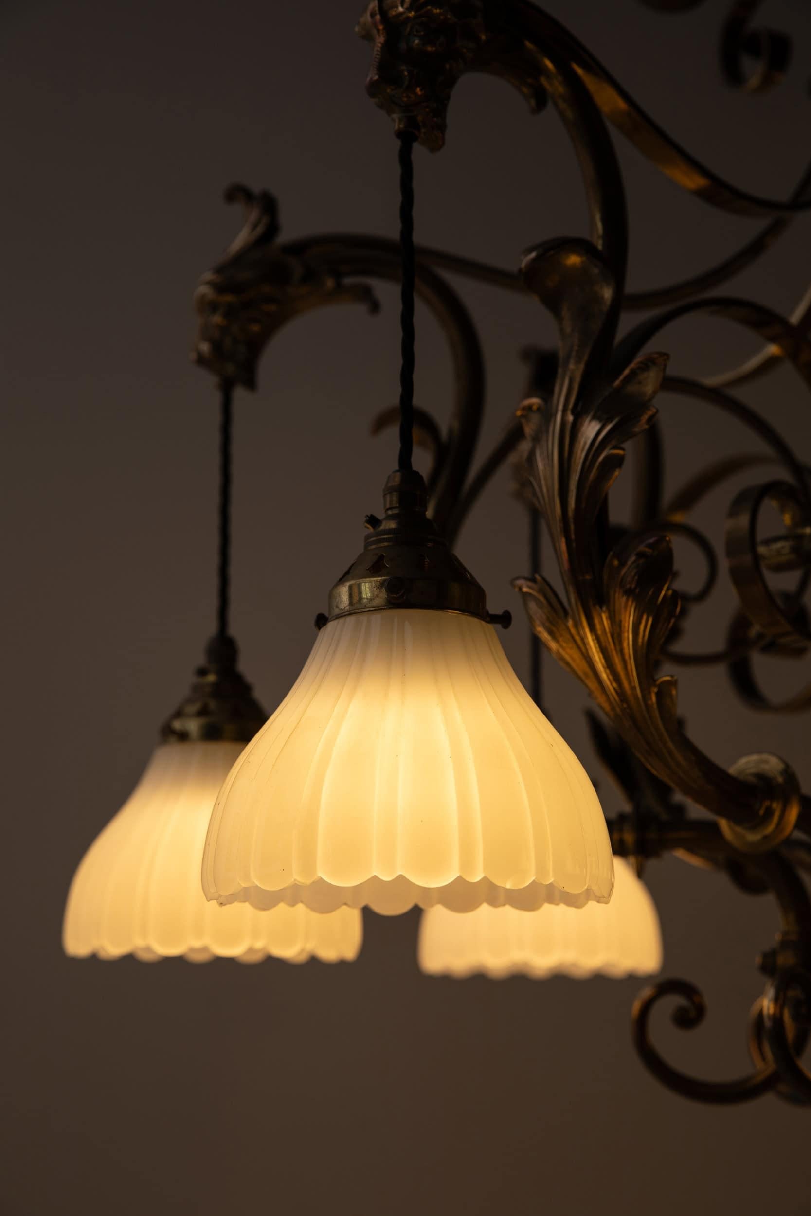 An incredible early 20th century electrolier made in England by F&C Osler. c.1910

Constructed entirely from brass to the highest quality with cast dragons heads to each branch supporting moonstone shades beneath. Central column with strapwork and