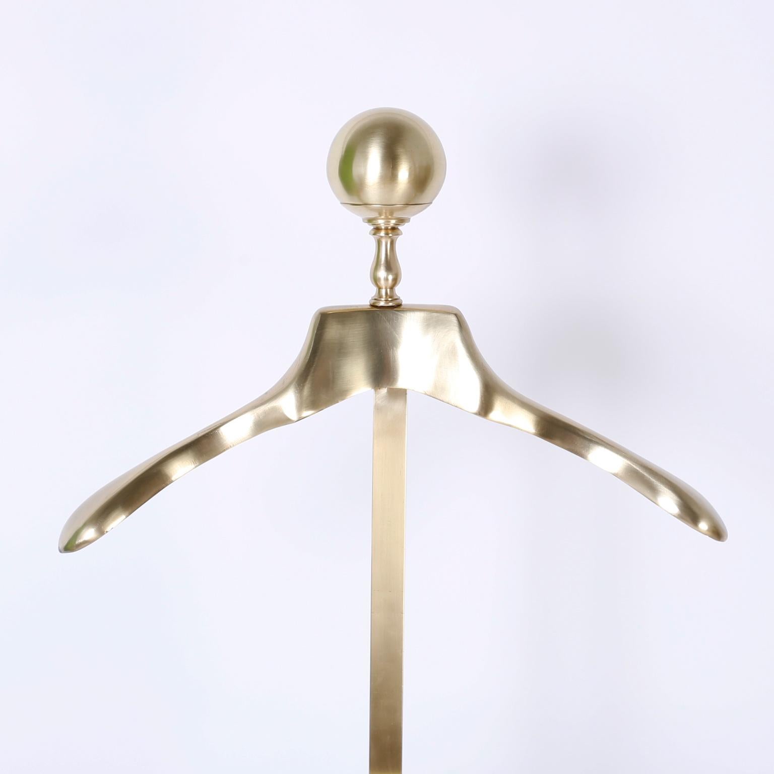 Victorian gentlemen's valet or silent butler crafted in brass with a Classic finial top, coat hanger, adjustable change and jewelry tray, trouser rack, and a three legged base. Hand polished and lacquered for easy care.