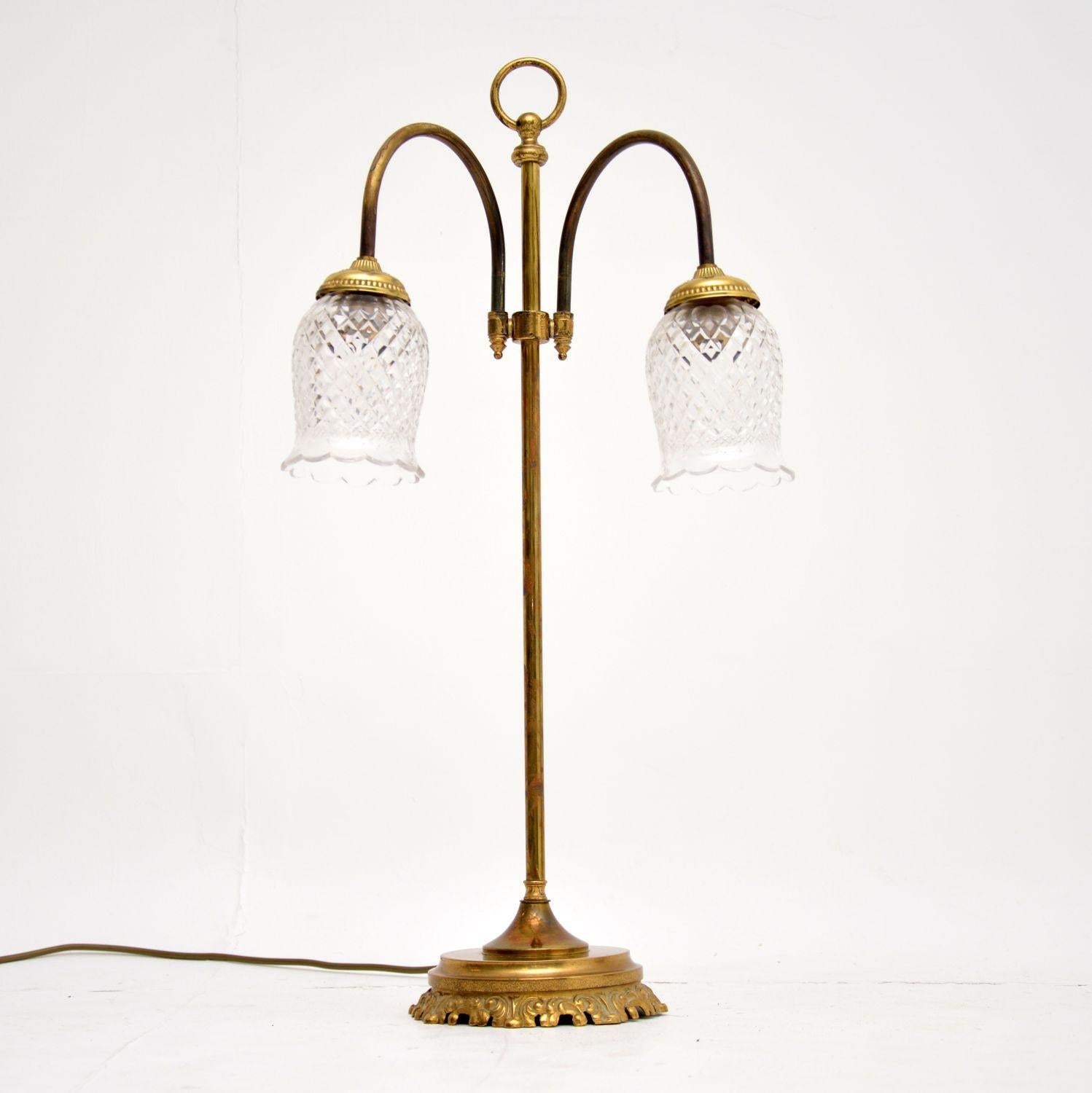 A beautiful and high quality vintage table lamp in brass and cut crystal glass. This dates from circa 1950s, it is in lovely original condition. The two brass arms can swivel and rotate to angle the light given off. The cut glass shades are