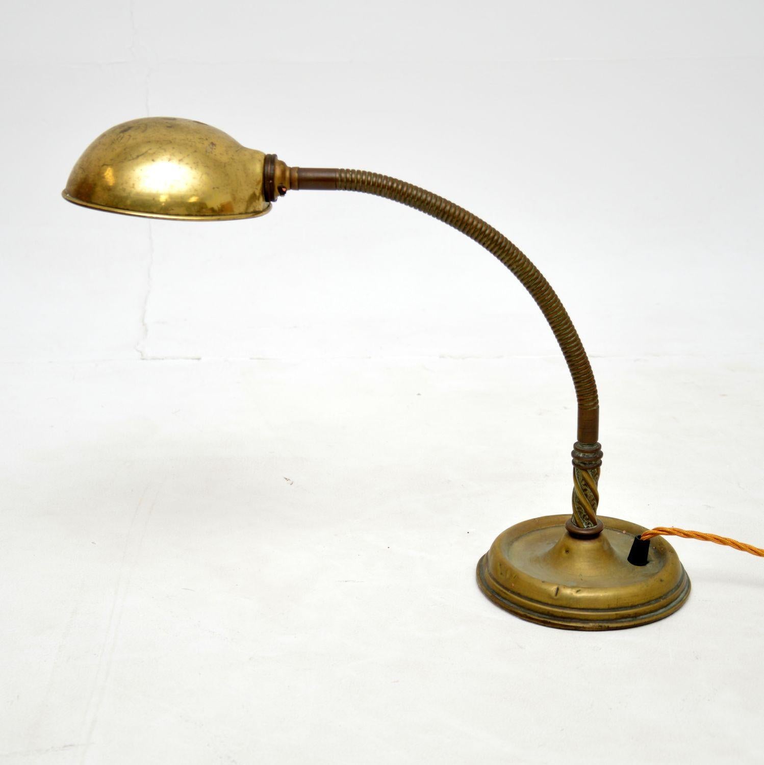 A charming antique desk lamp in solid brass, this was made in England and dates from the 1900-1920 period.

It is very well made, with an articulated goose neck that can be adjusted to various angles.

The brass has an absolutely gorgeous
