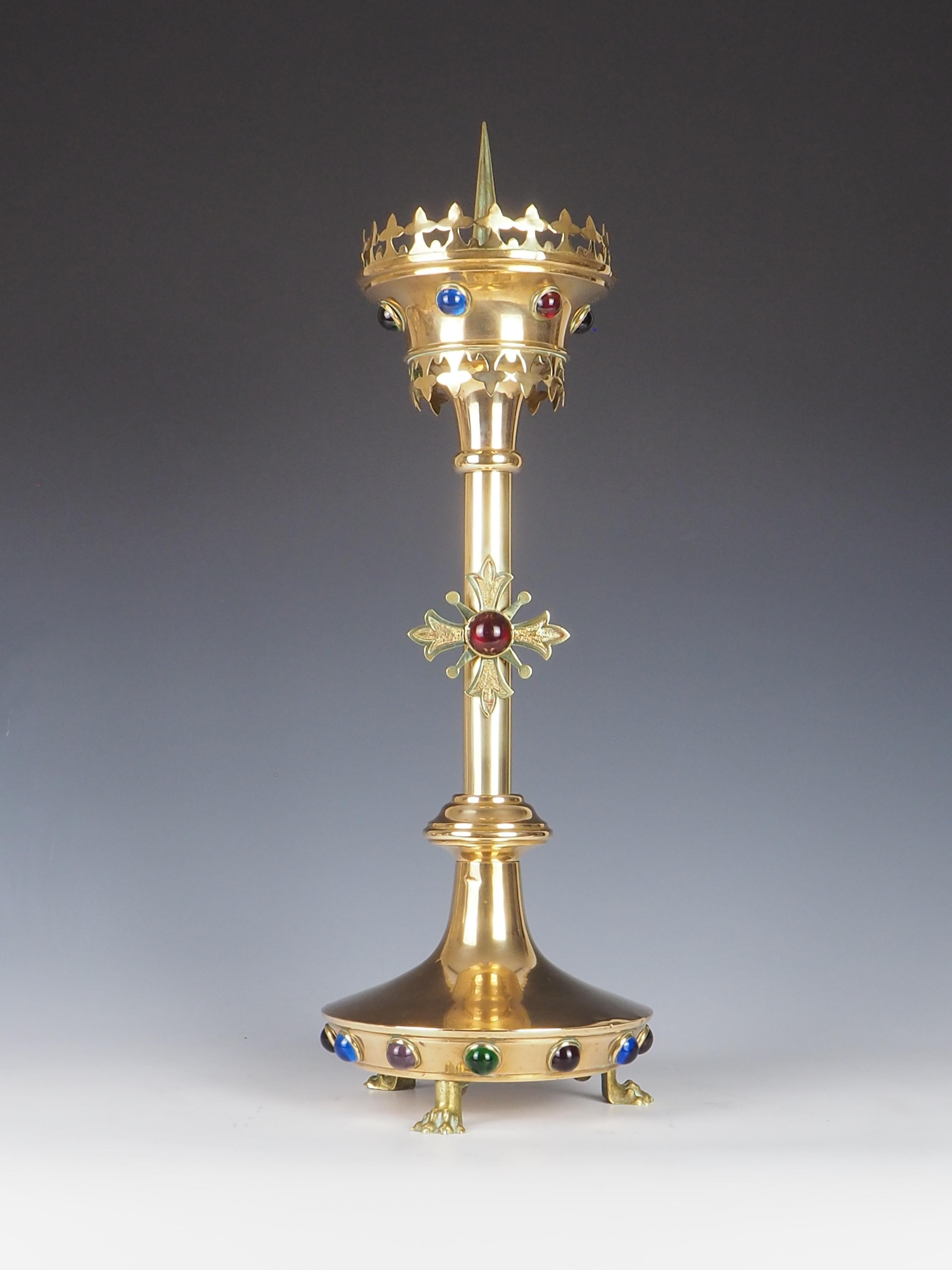 Exquisite Antique Brass Gothic Revival Church Candle Holder is a stunning piece that embodies both artistry and craftsmanship.

Standing firmly on three intricately detailed claw feet, it showcases superb quality that is evident from its robust