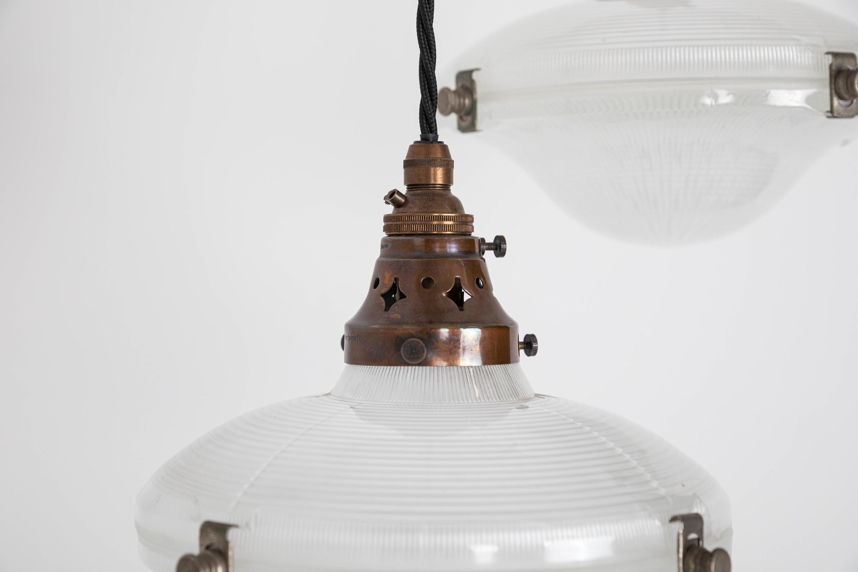 A pair of glass reflector pendant lights made in England by Holophane. c.1920

Often wrongly coined as 'flying saucers', the correct name being the 'Ripple-lite' - these two-part glass reflector shades have survived in wonderful condition