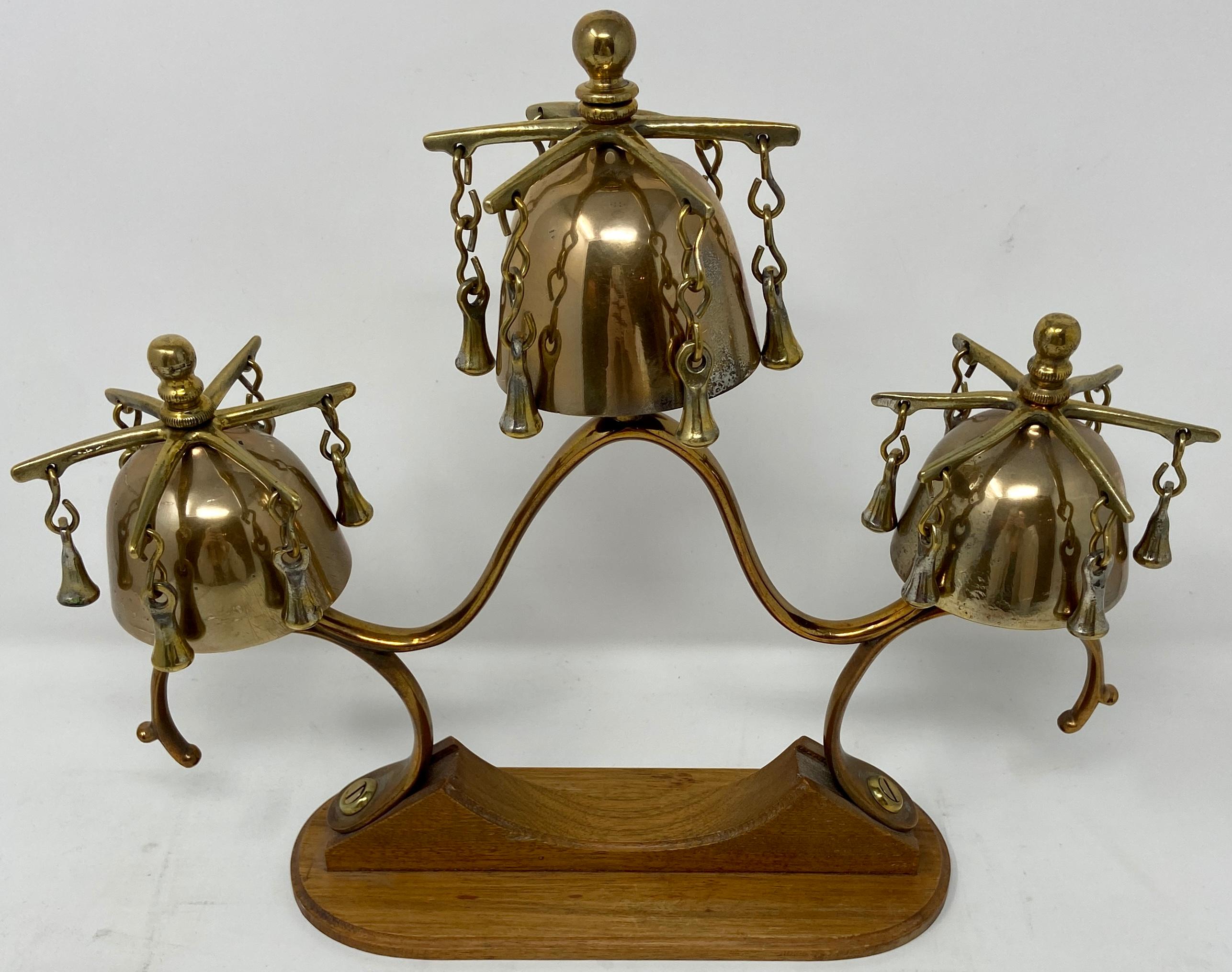 Antique brass horse hames design sleigh bells on stand, circa 1900.
