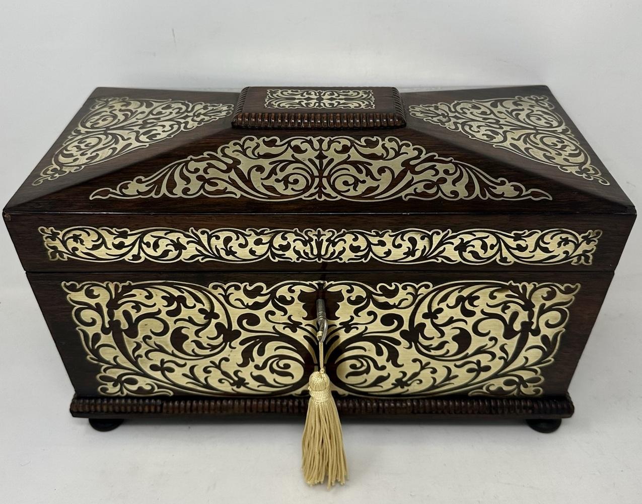 Superb example of an English Regency Rosewood Double Tea Caddy of traditional sarcophagus outline and unusually large size, with lavish brass inlay decoration. The dome shaped hinged lid enclosing a complete original fitted interior, including a
