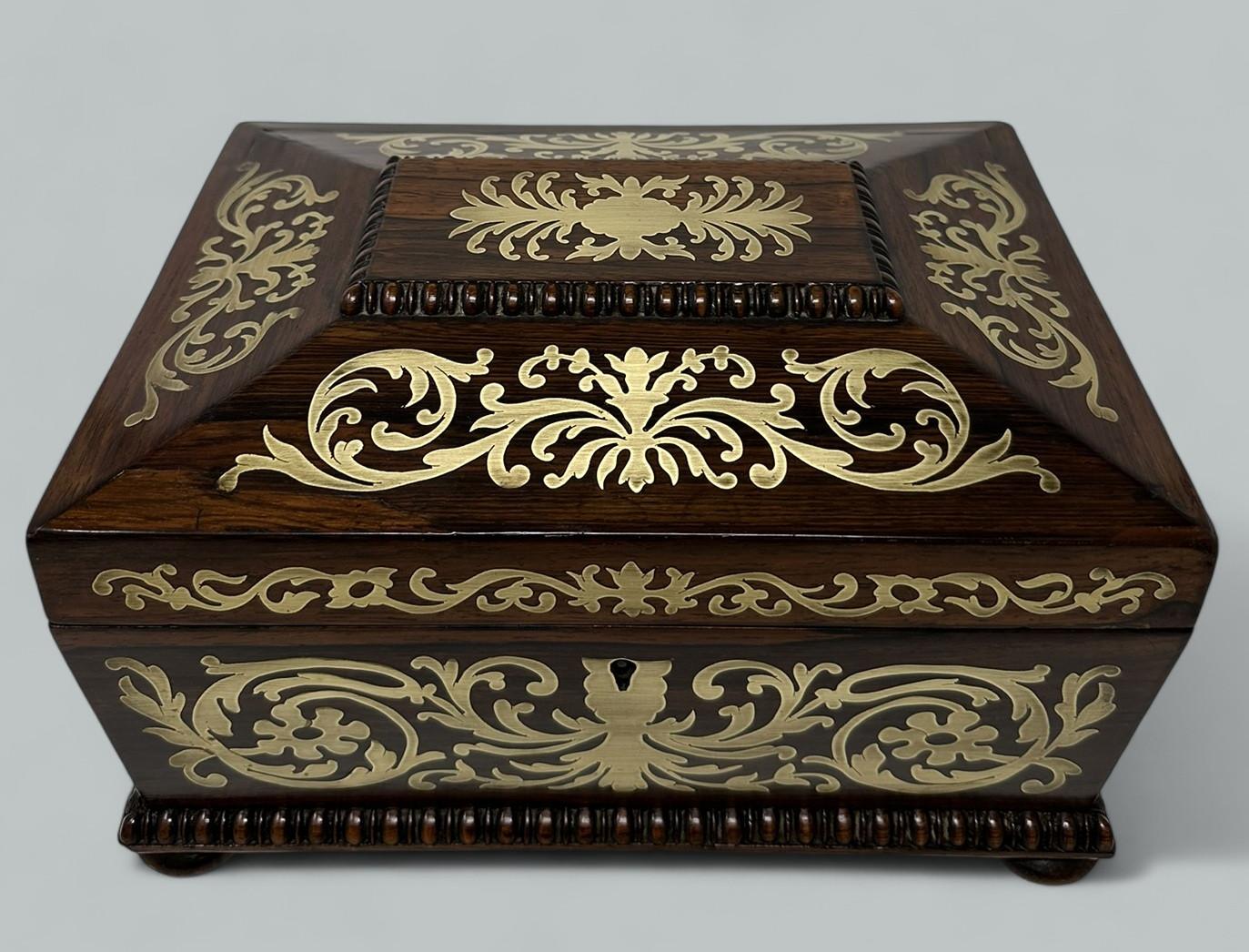 An exceptionally fine quality example of a Lady’s or Gentleman’s English Regency Period polished brass mounted well figured Rosewood inlaid Boulle Style Jewellery or Sewing Casket or Table Box made during the first quarter of the Nineteenth Century,