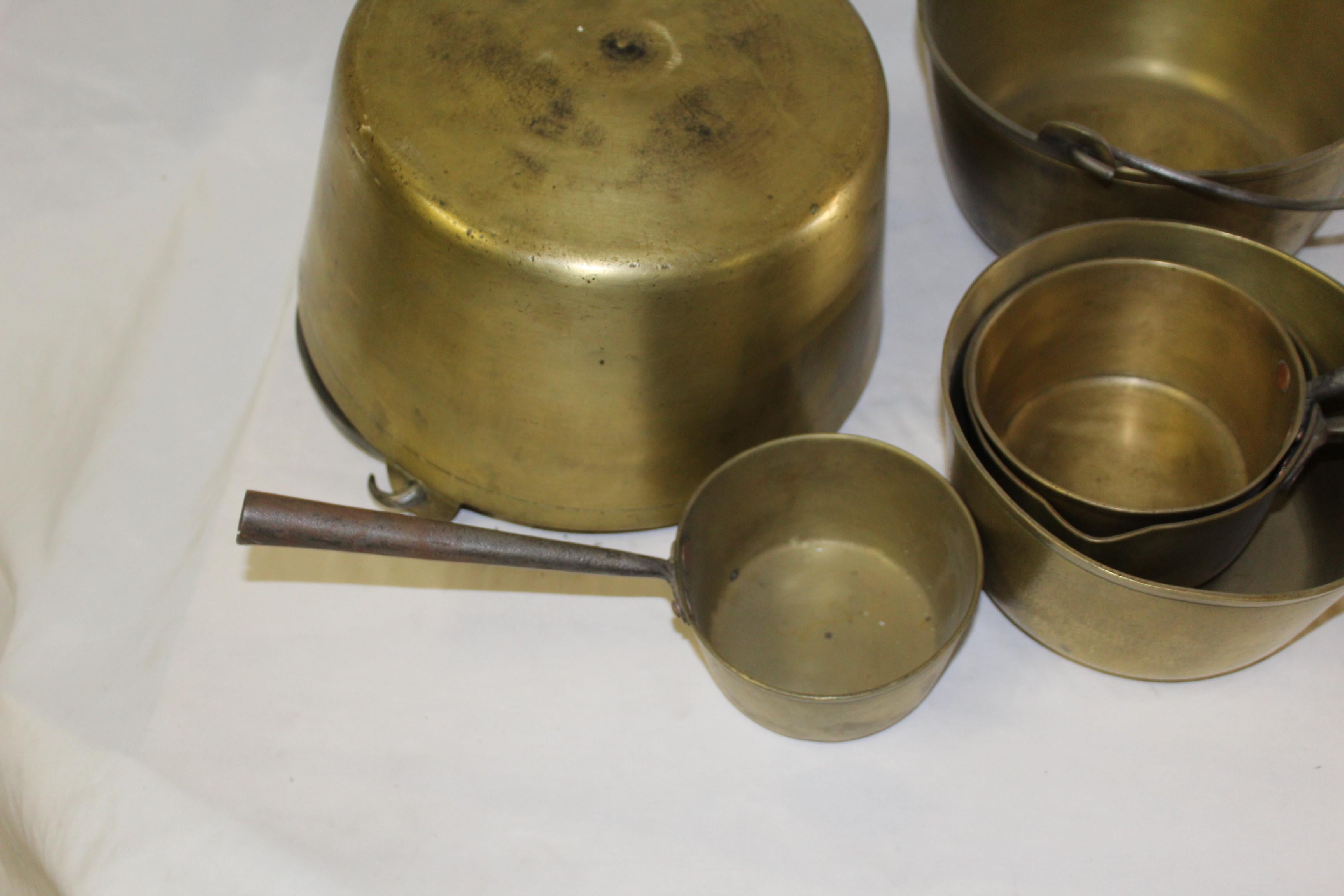A set of solid brass cooking pots. Handmade steel handles with copper rivets used to attach the handles. All cleaned up and well taken care of. Great for displays or can be used. The large one is 12