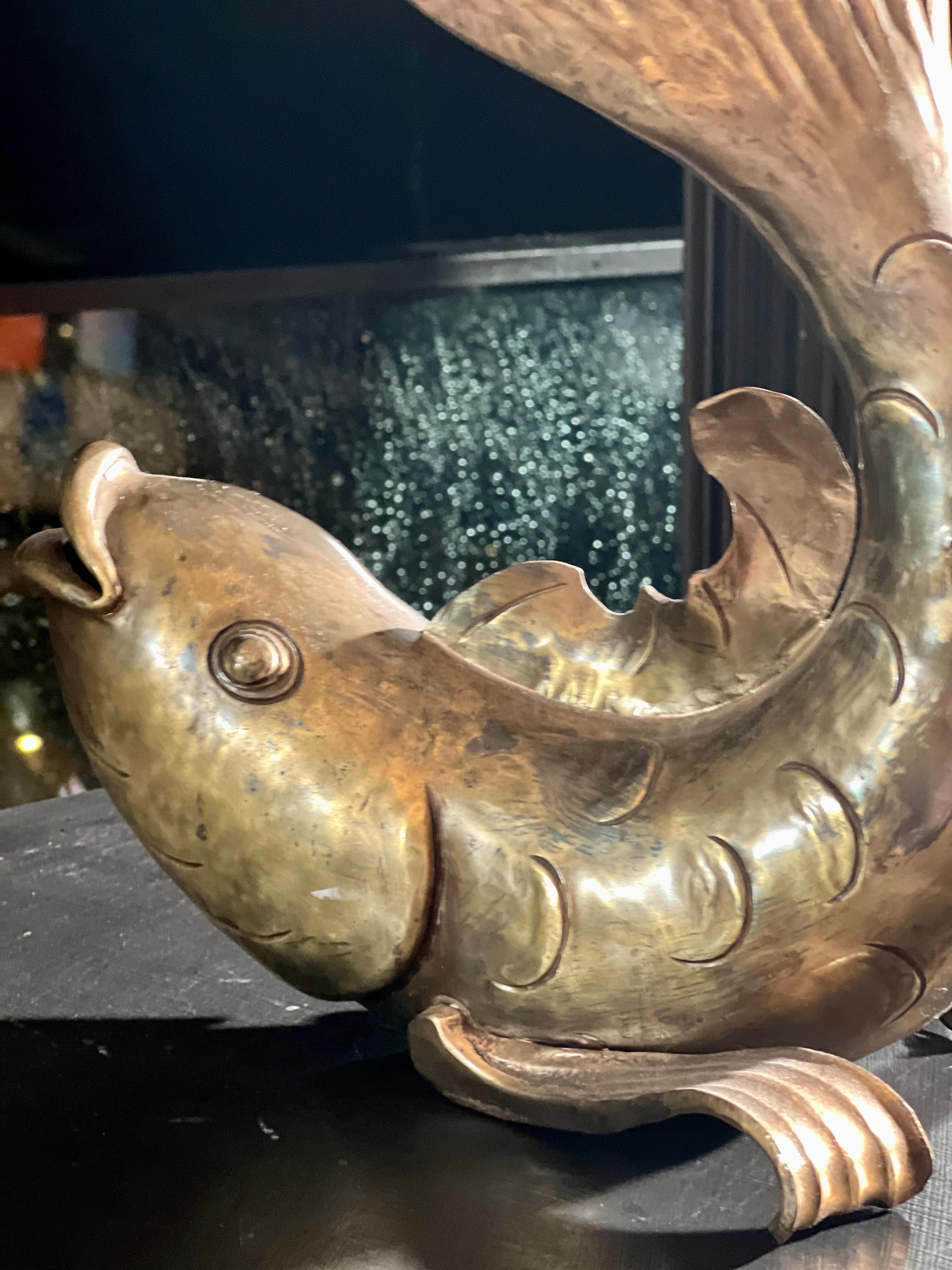 Gilded Aquatic Majesty: A Mesmerizing Bronze Fish Gracefully Adorns an Exquisite Table

In the opulent surroundings of a lavish European family home, adorned with exquisite artwork and rare treasures, there sat a magnificent antique brass Karpe fish