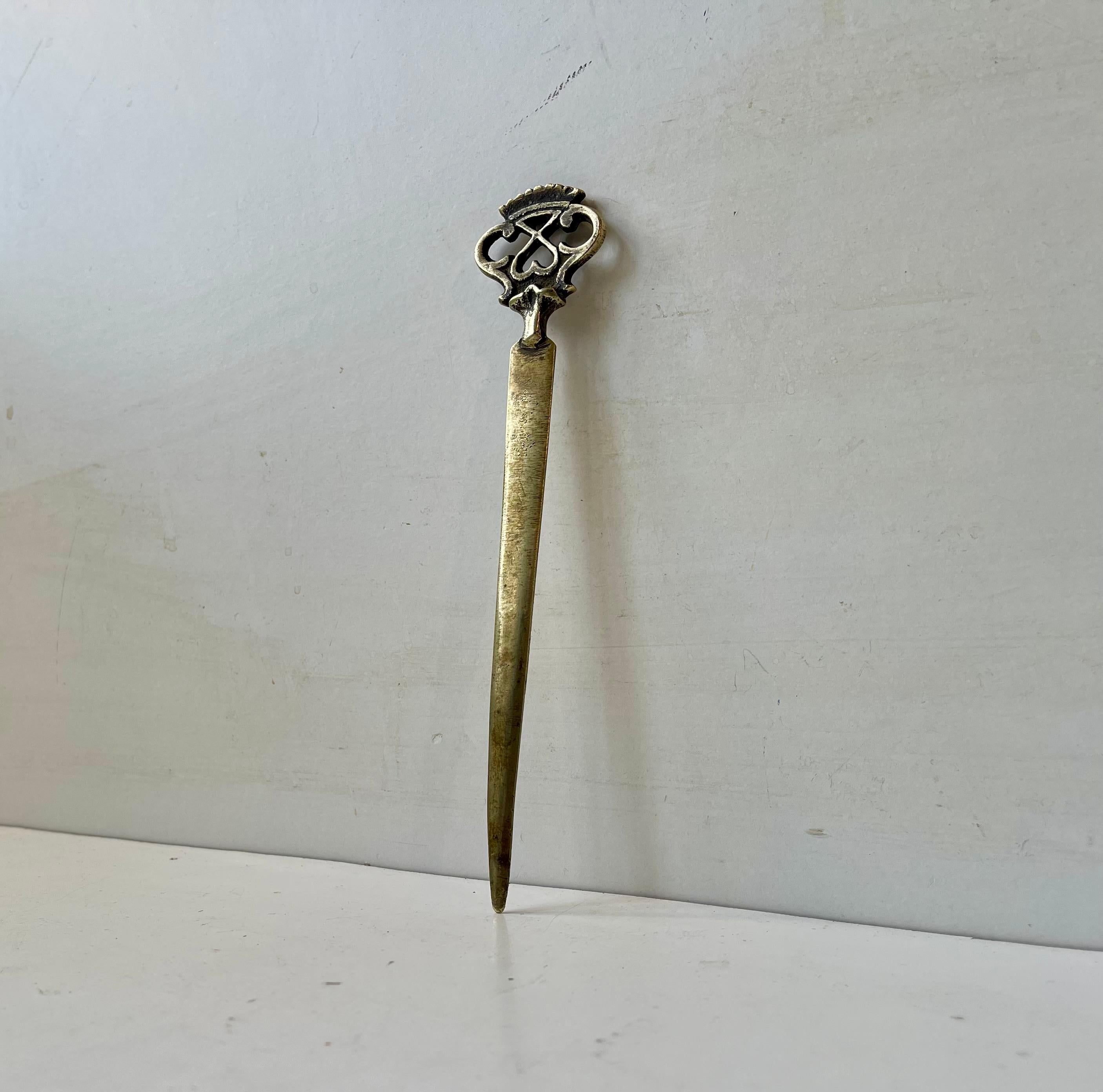 Unusual paper knife in solid brass. Its top depicts a Celtic cifer with symbolism of both love and power. It was made in Europe during the 19th century. It has indistinguishable markings to one side just below the cifer.
It would make a great and