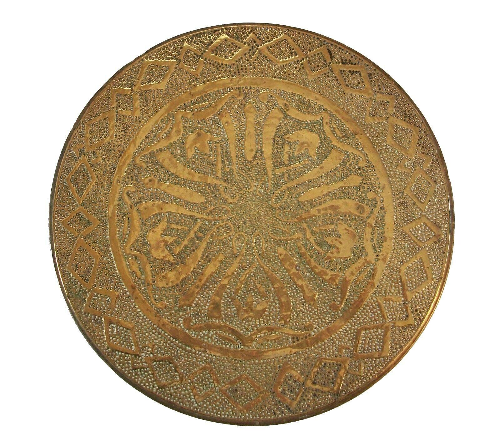Rare antique American needle embossed circular brass trivet with central tulip pattern - Arts & Crafts style - diamond shaped border - stepped edge - wood base with hand hammered brass feet/balls - unsigned - United States - circa 1910.

Excellent
