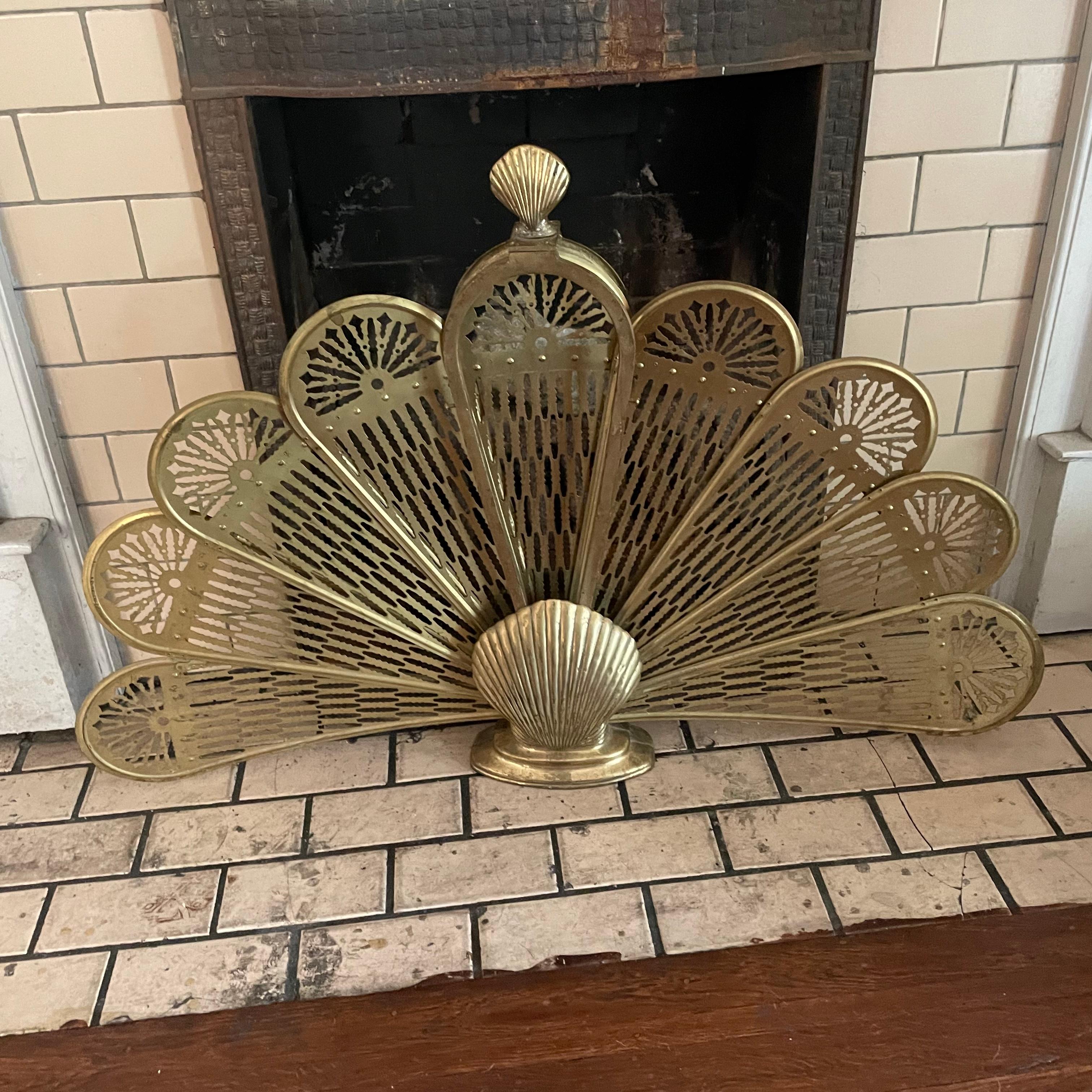 Up for grabs is this awesome fireplace screen made of brass in a fan-style that can fold up and be tucked away when not needed. There are two latches on both sides that can be lifted for the screen to fan out. This one has two brass shell motifs on