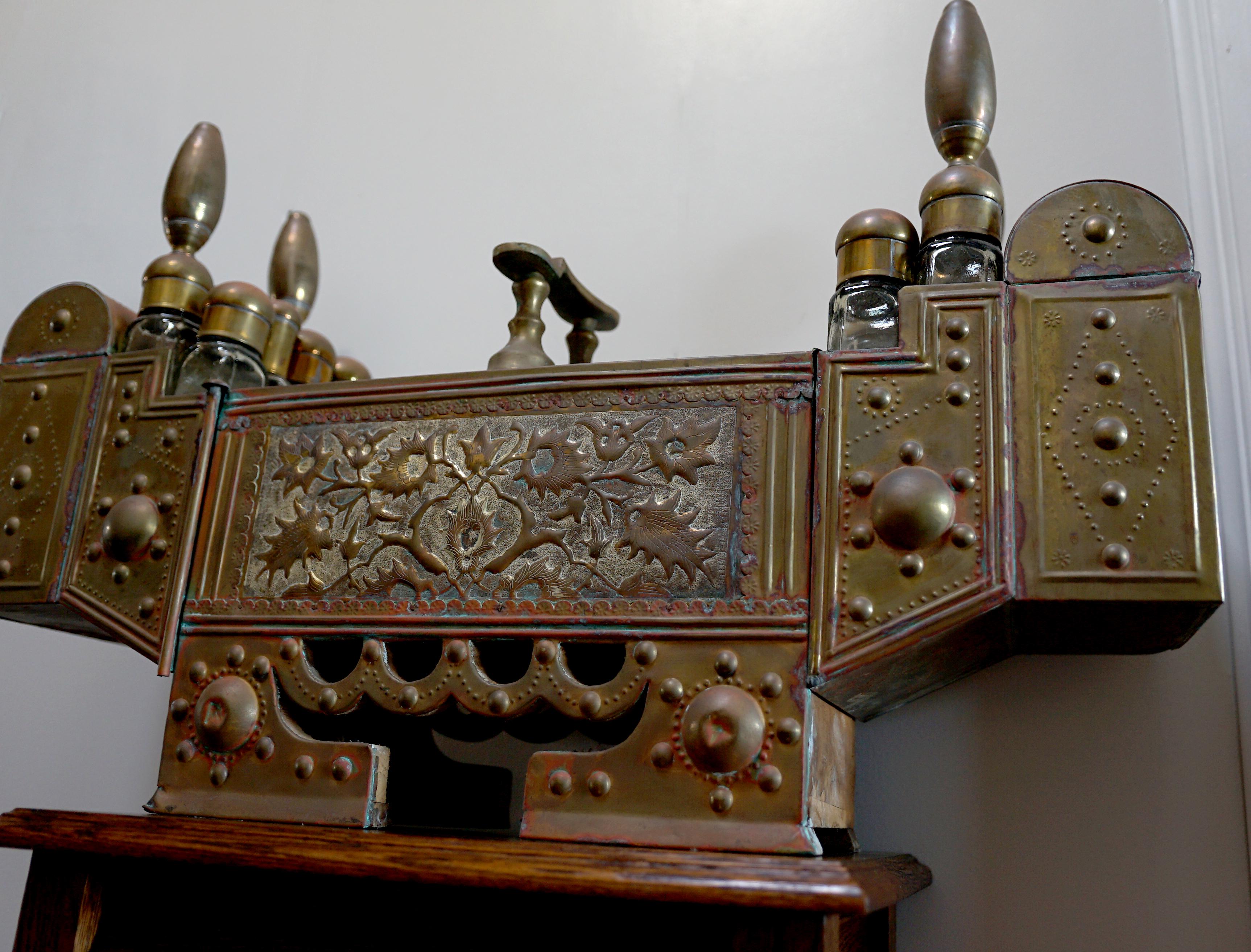 The beauty is in the details of this Turkish antique Brass Shoe Stand. The details include accessories like an old shoe shine kit  with bottles and tops. that came from Istanbul. The face of the stand features stunning Arabic calligraphy. This piece