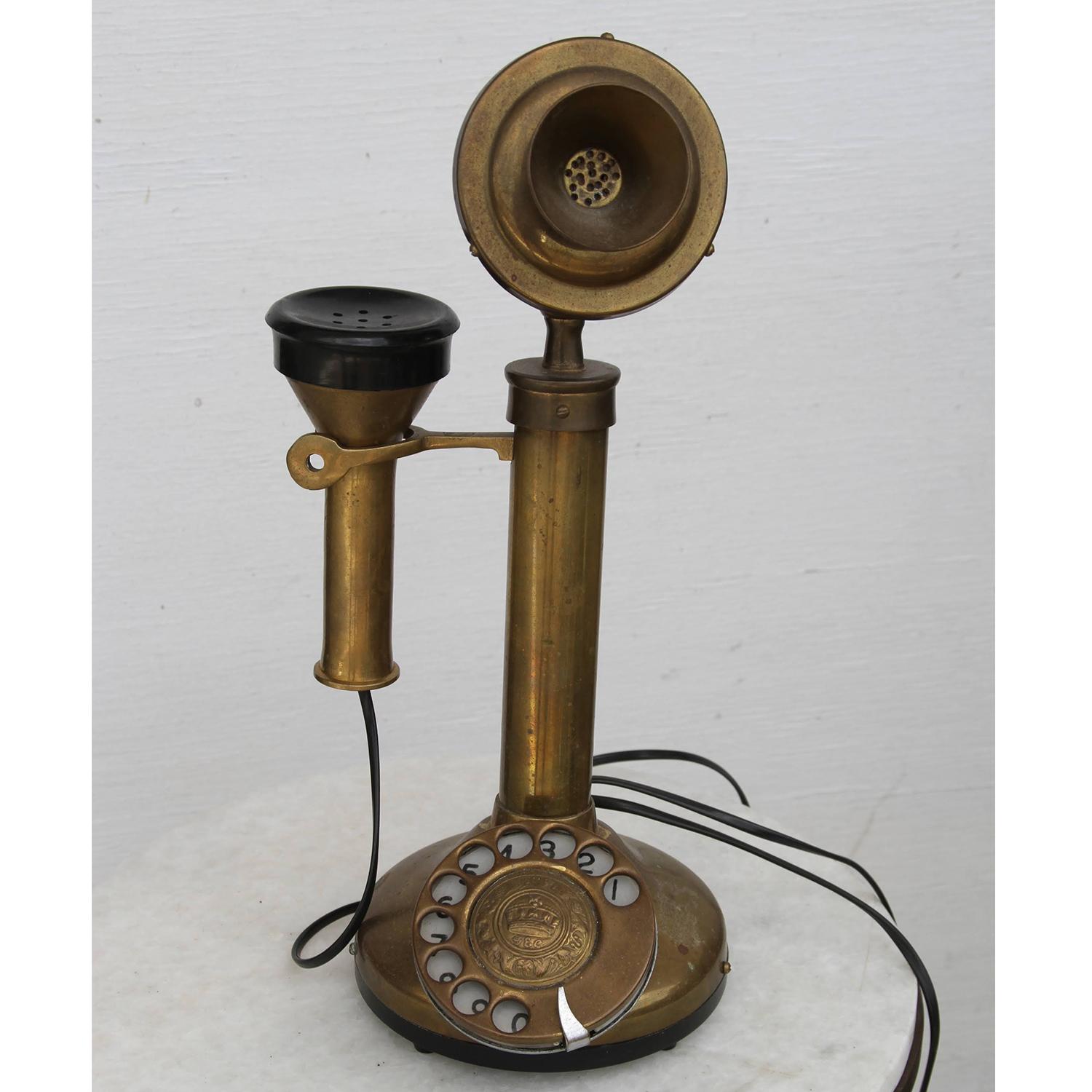 Antique brass telephone


 Candlestick telephone with rotary dial and desk stand in brass.
Nicely aged with light marks. Wired.
This type of telephone was popular from 1900 to the 1950s. These telephones are also referred to as pedestal