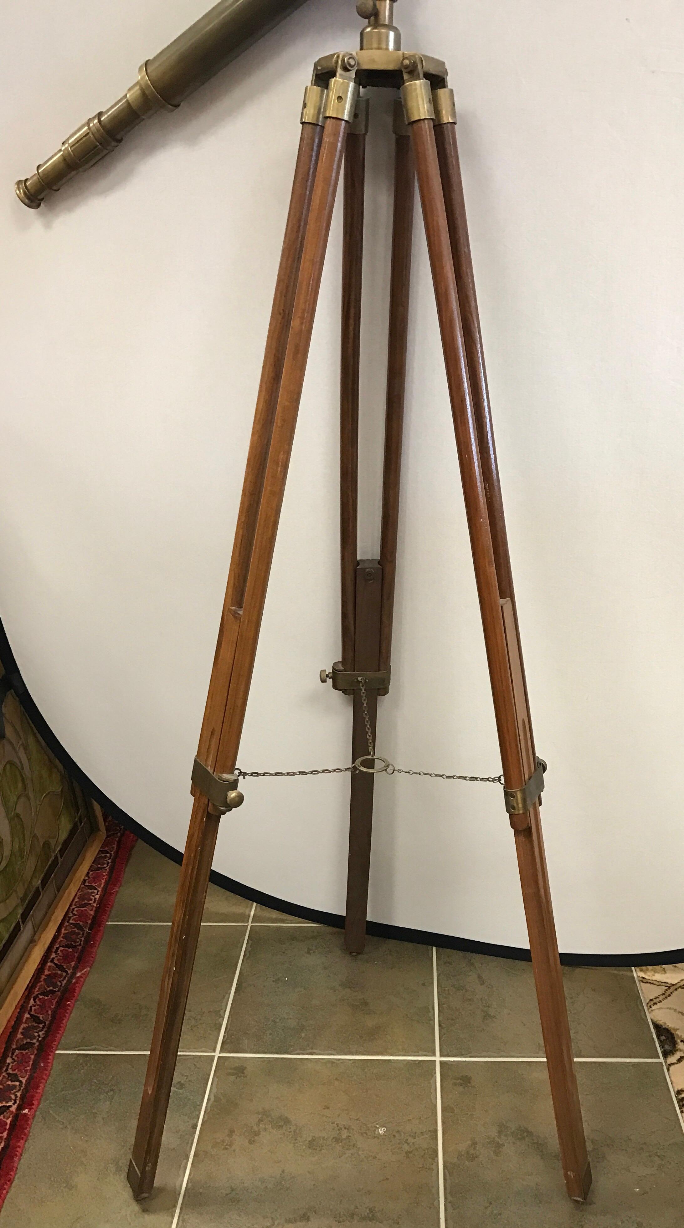 Antique brass telescope on standing tripod base in working condition.