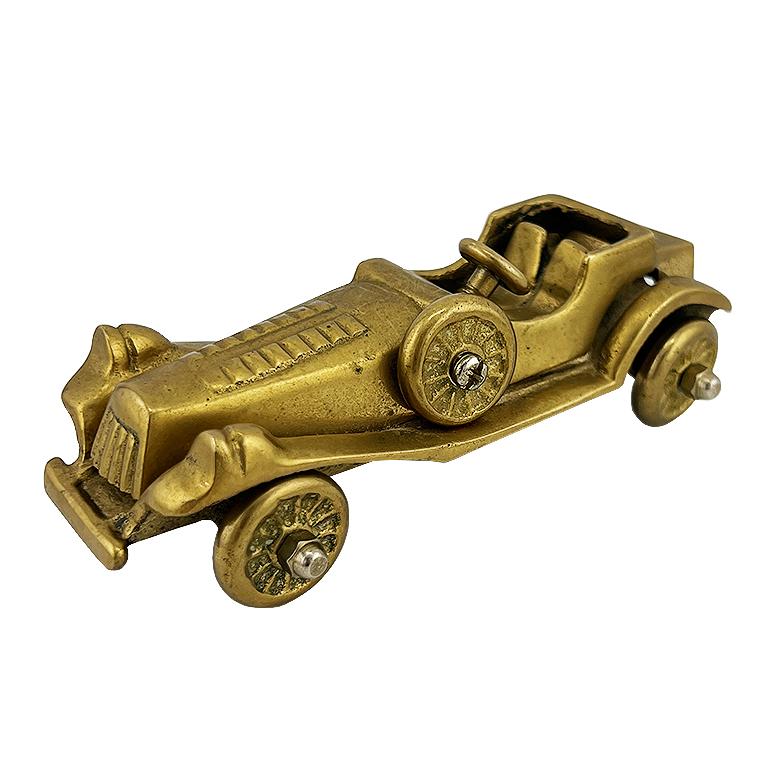 Cette voiture jouet antique en laiton est une rare et charmante relique du début du XXe siècle, méticuleusement moulée en laiton massif avec une attention particulière aux détails de l'automobile d'époque. Avec ses roues à rayons, son capot