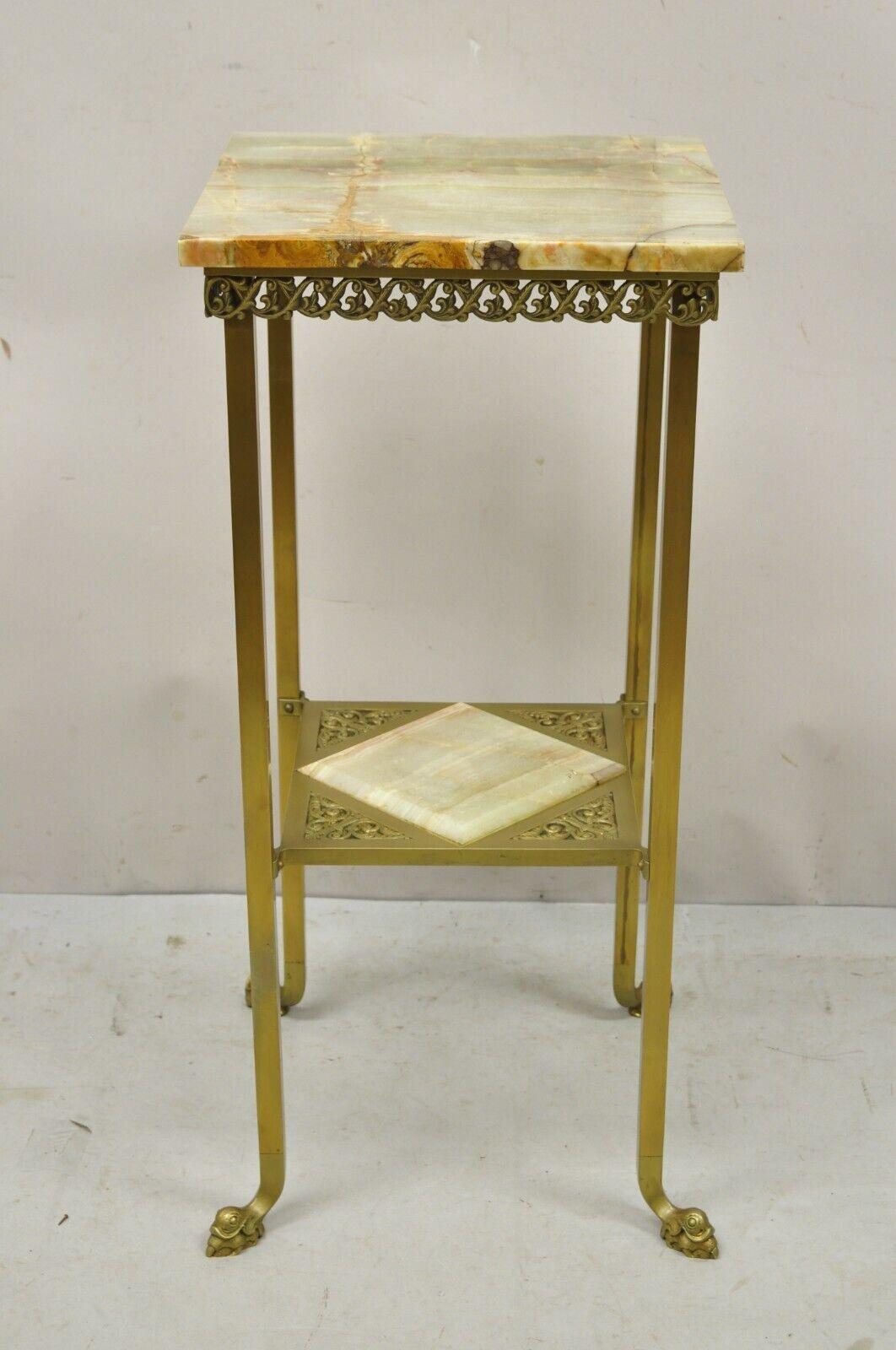 Antique brass two tier onyx stone dolphin feet plant stand side table. Item features dolphin feet, brass 2 tier base, two onyx stone surfaces, scrollwork skirt, very nice antique item, great style and form. Circa 19th Century. Measurements: 30.25