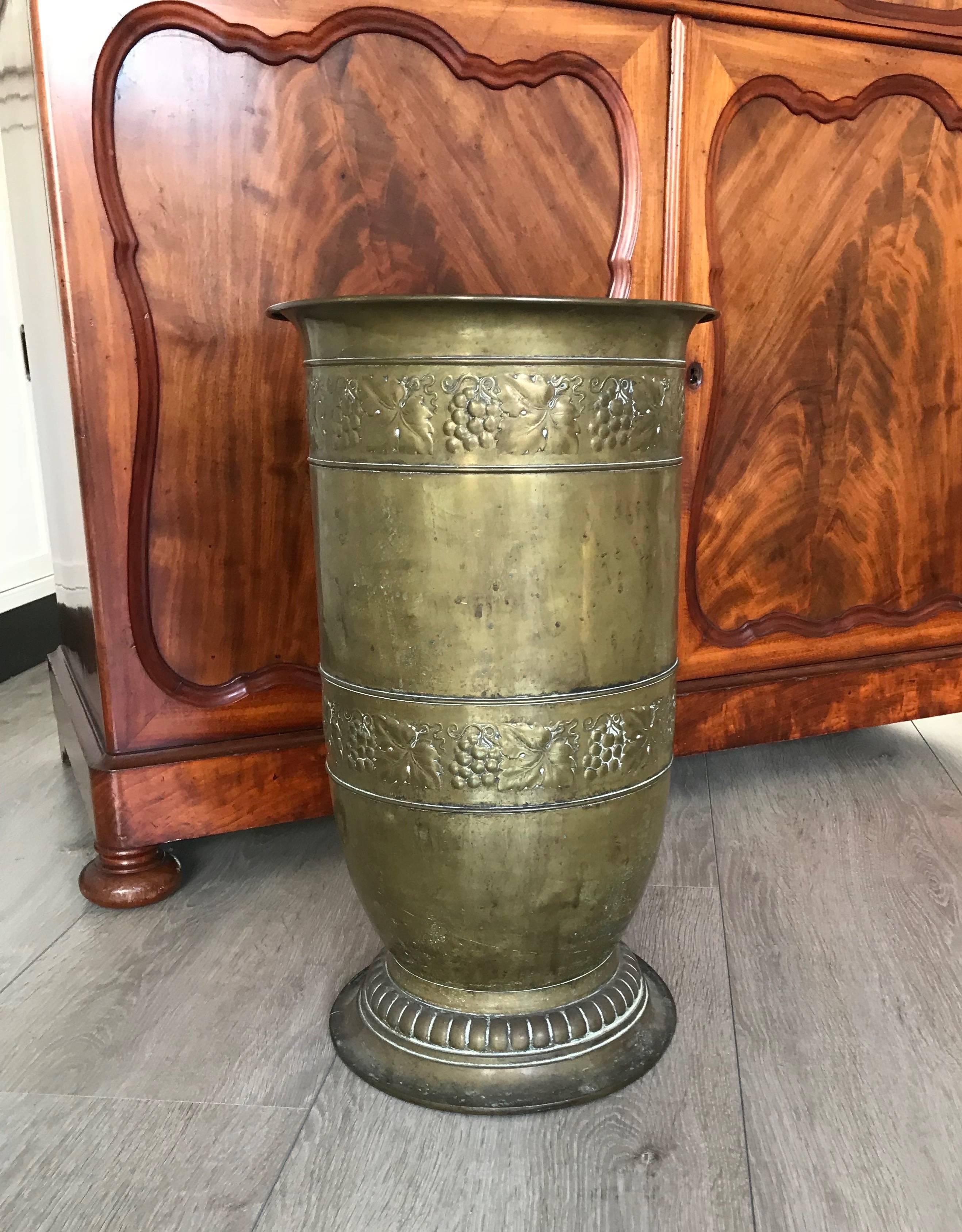 Looking for a stylish and practical antique to upgrade your entrance? 

This beautifully embossed brass collect umbrella stand will look beautiful in your entrance or hallway. This Arts and Crafts design from the early 1900s is made and marked on