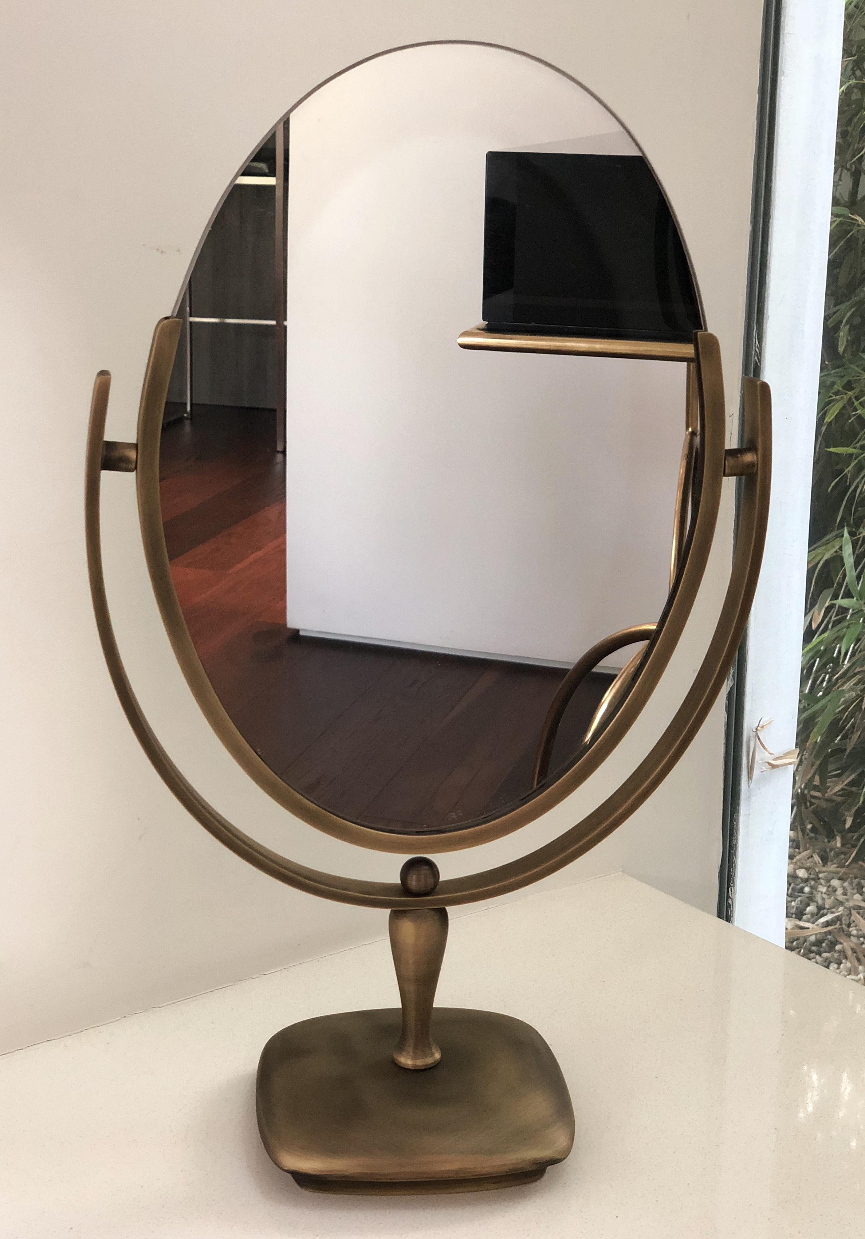 Wir präsentieren den Vintage Vanity Mirror in Antique Brass von Charles Hollis Jones, ein zeitloses Stück amerikanischer Handwerkskunst aus dem Jahr 1968. Dieser exquisite Spiegel strahlt Luxus und Raffinesse aus und ist damit die perfekte Ergänzung