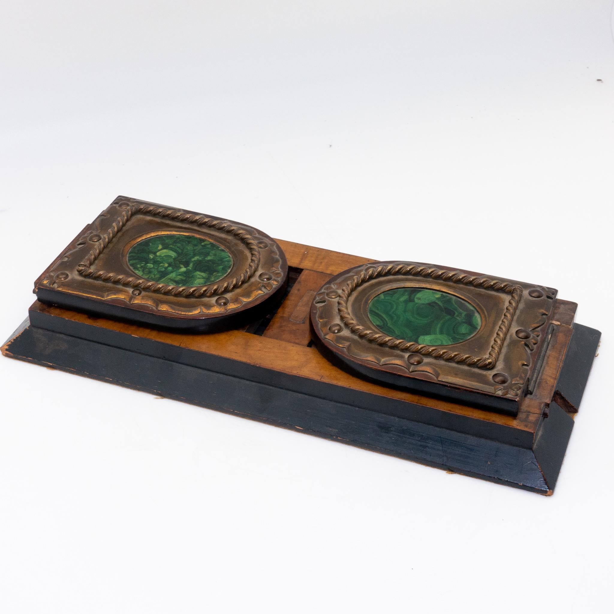 A beautiful Victorian brass-mounted Coromandel wood sliding book rack with inset malachite plaques. Made to the Betjemanns patented slide design; engraved with patent number 10597.

In 1812 and at the age of 14, George Betjemann started