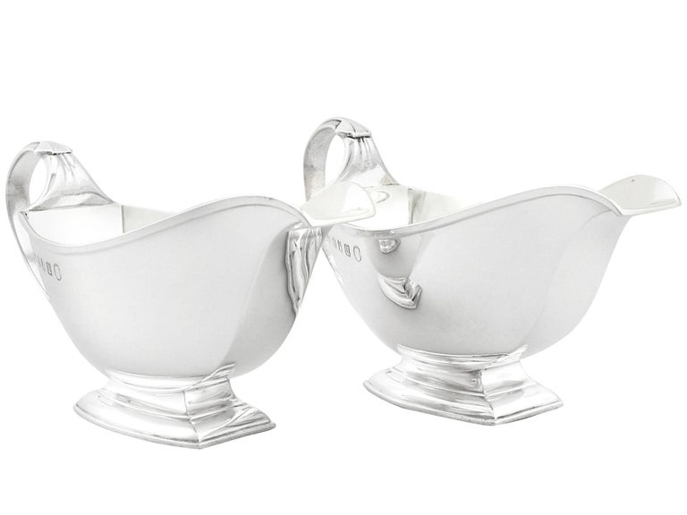 An exceptional, fine and impressive pair of antique George V Britannia standard silver gravy boats; an addition to our dining silverware collection.

These exceptional antique George V Britannia standard silver gravy boats have a plain rounded