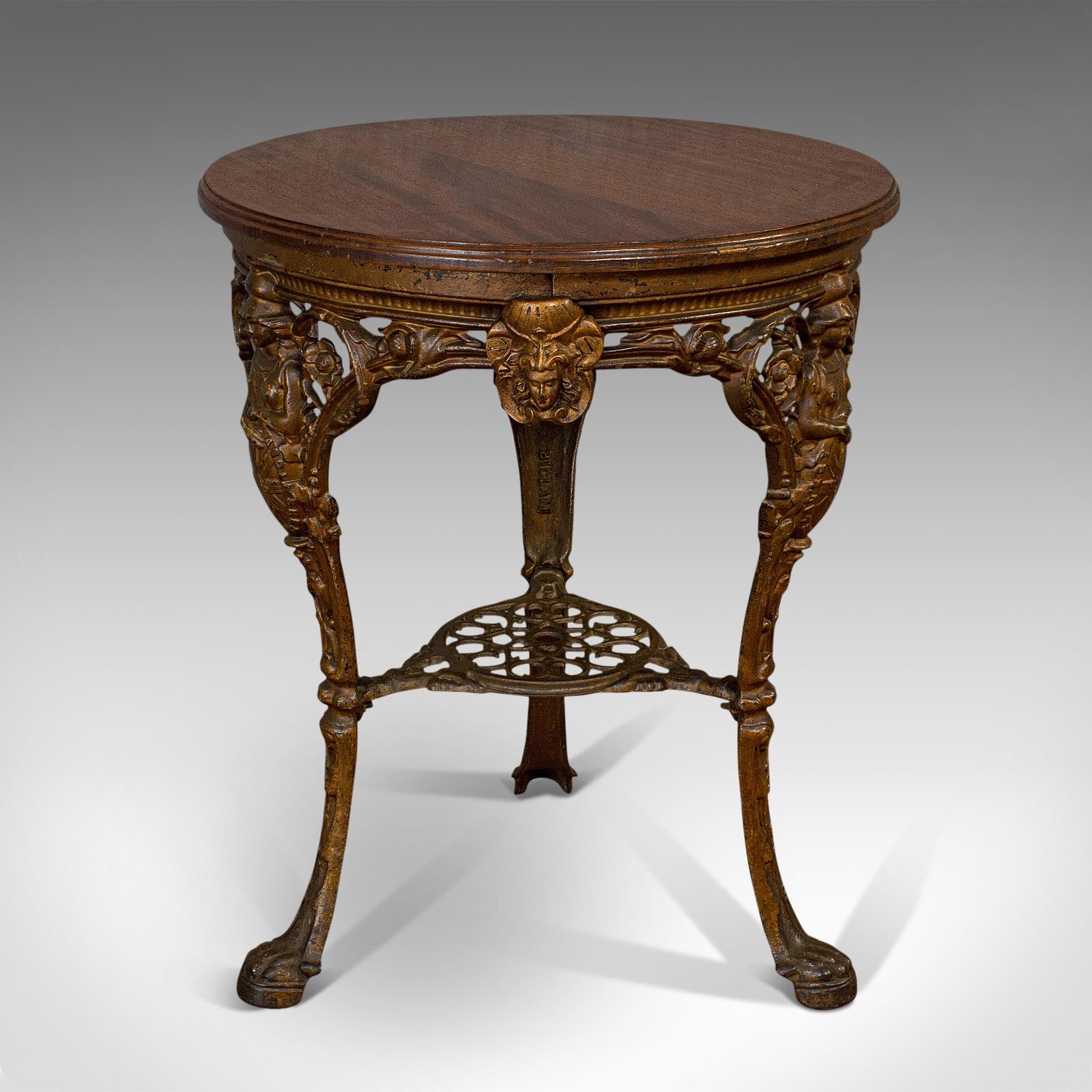 This is an antique Britannia table. An English, mahogany over cast iron outdoor garden table from the Biclam Foundry, dating to the late 19th century, circa 1880.

Appealing table with dark hues throughout
Displays a desirable aged