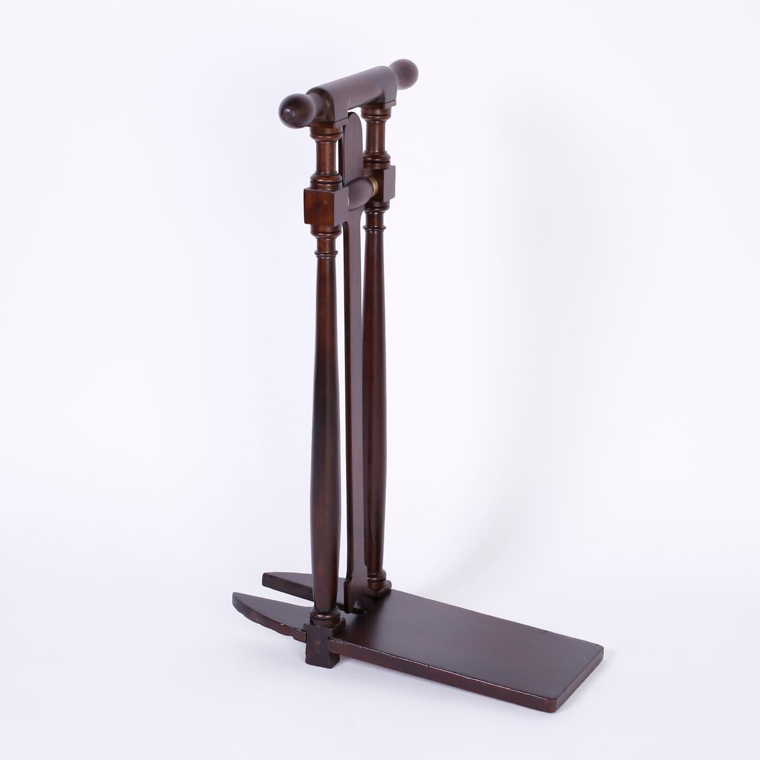 Antique Caribbean boot jack expertly crafted in mahogany with sturdy top handles, two turned supports columns, swinging leverage aperture, and standing platform. This is the intersection of style and function.
 