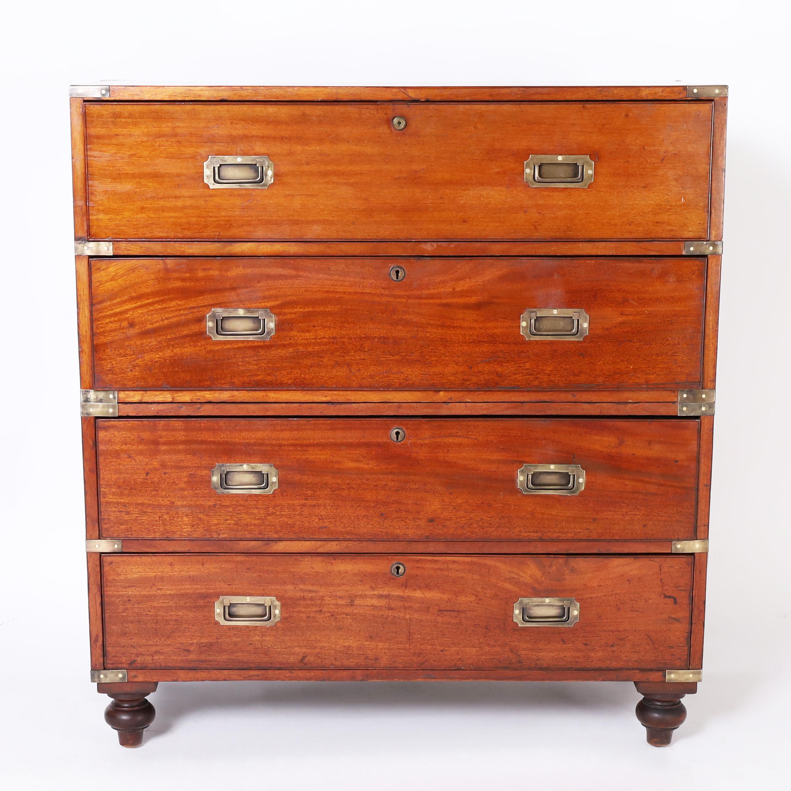 Handsome 19th century campaign chest secretary handcrafted in mahogany in a two-piece construction featuring a pull-out leather top secretary desk with nooks and drawers, three storage drawers below, brass hardware and turned feet.
